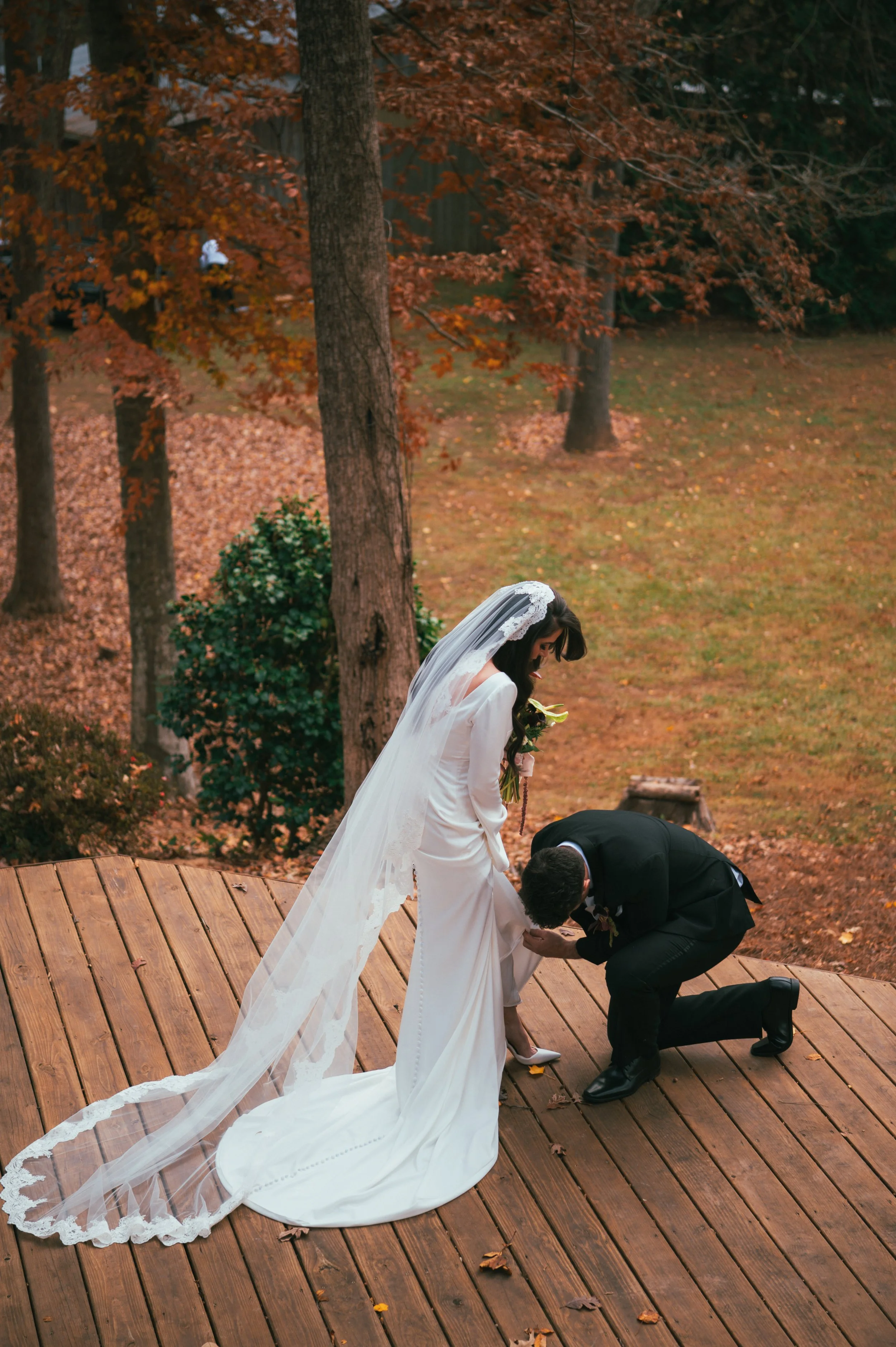 Groom helping bride put her shoes on in North carolina USA