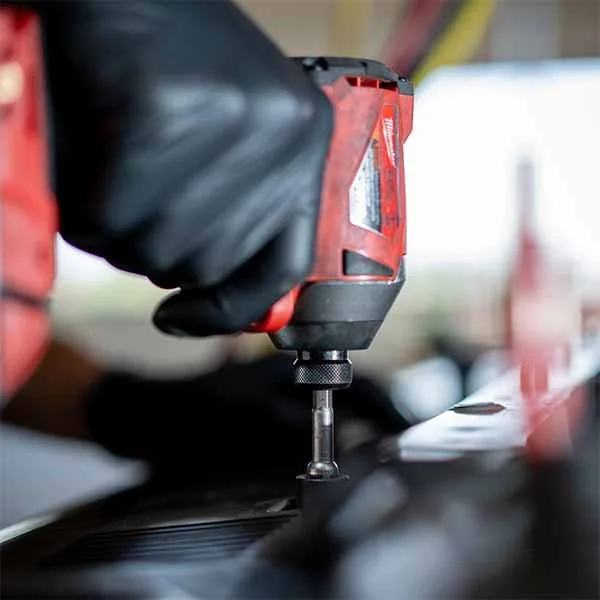 Technician using impact driver during on-site auto repair
