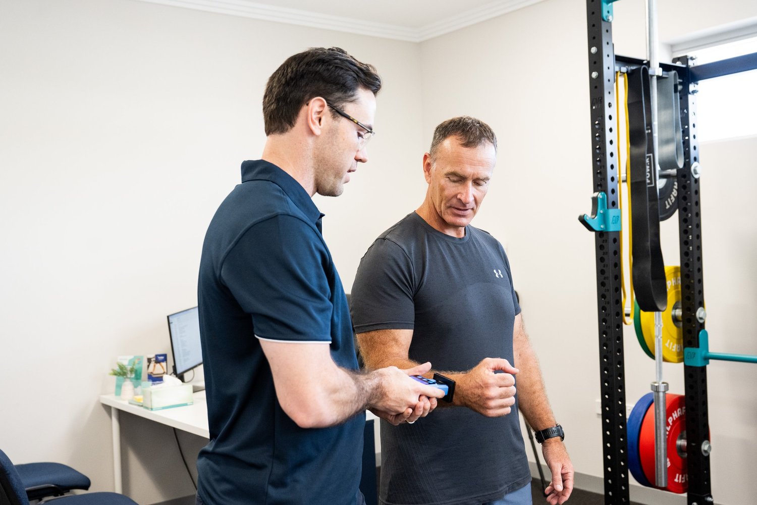 Mick supporting an athlete at an AFL field during return-to-sport rehabilitation