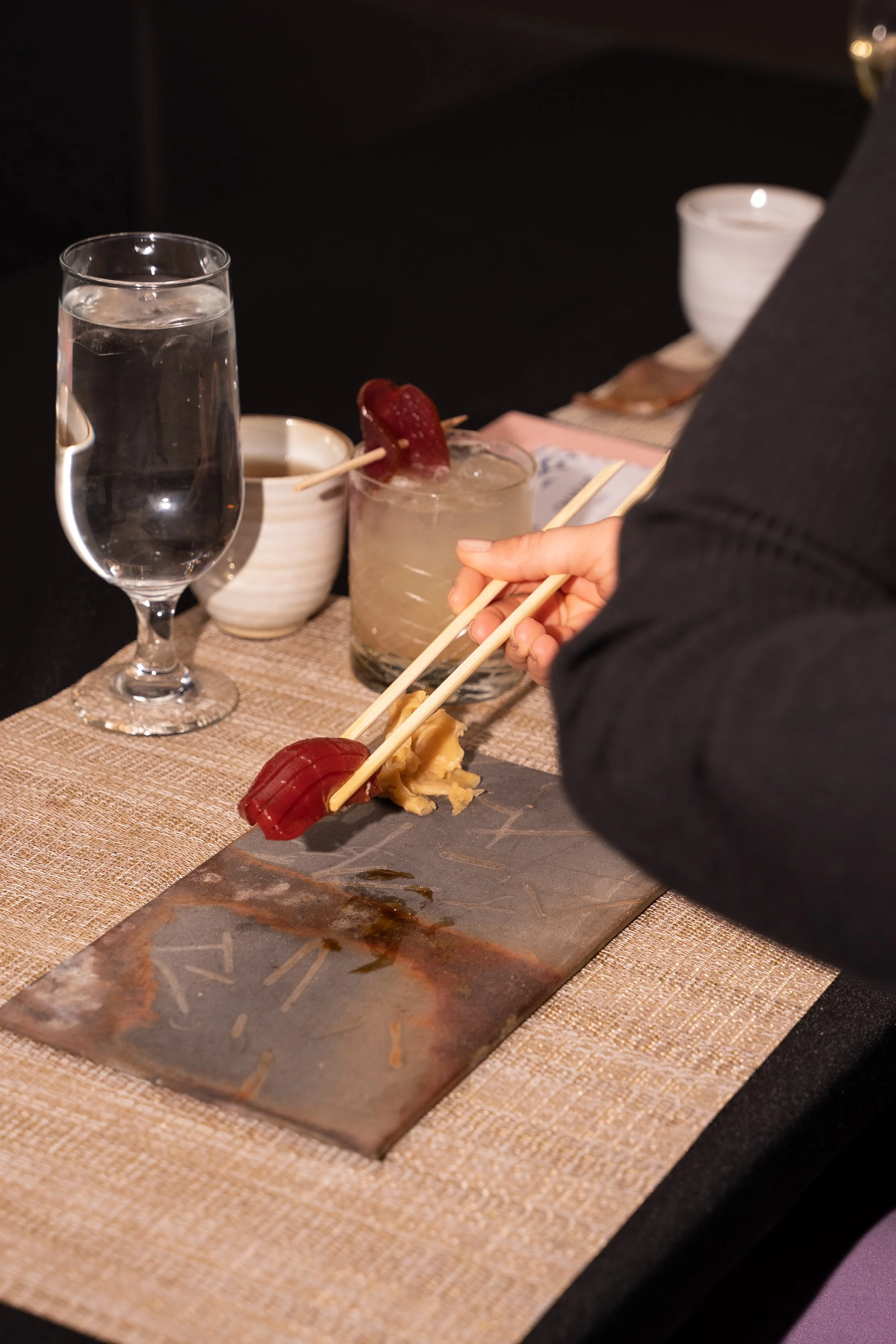 Guest enjoying sashimi with chopsticks at Sora Cleveland’s omakase dinner