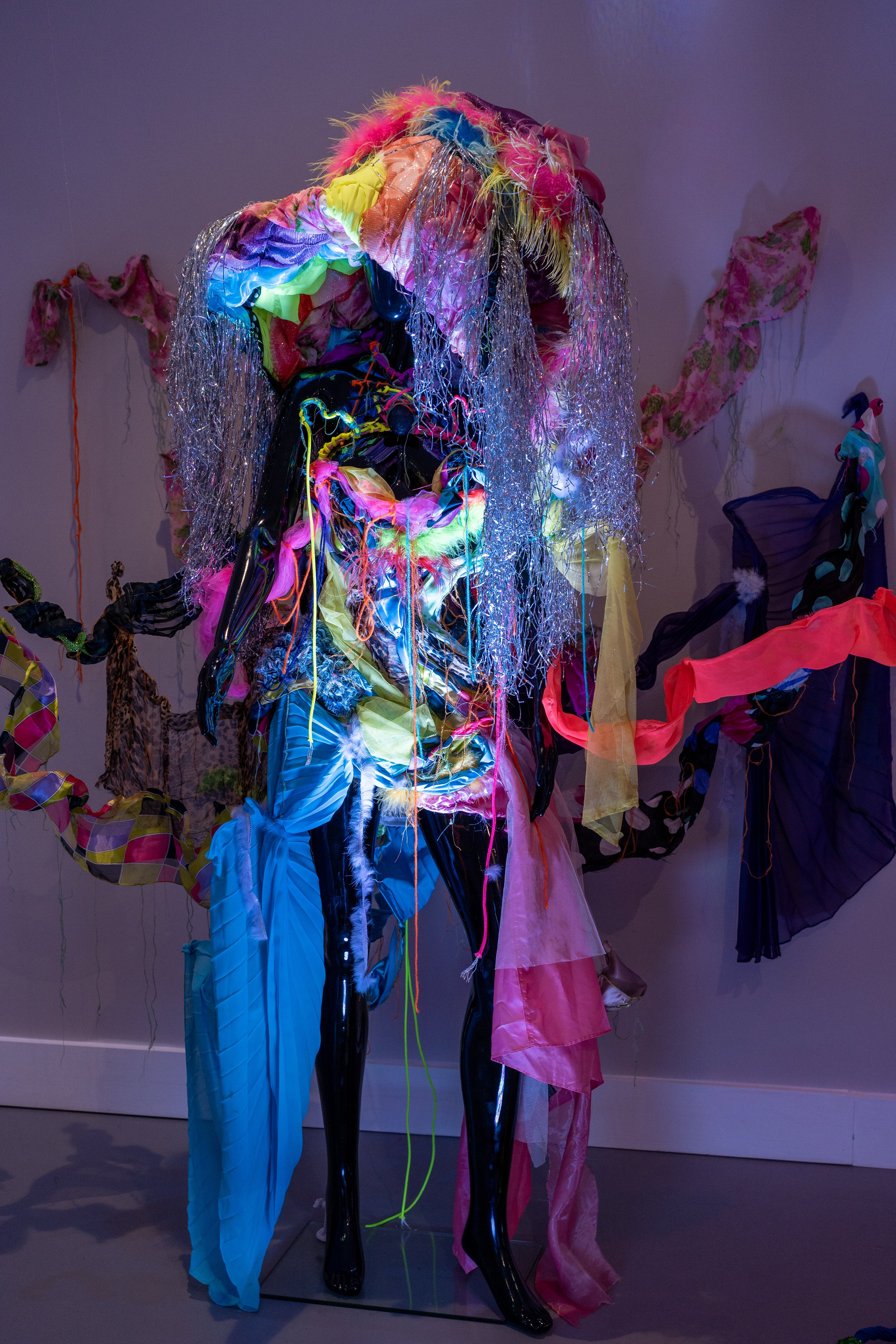 Colorful abstract art installation with mannequin and vibrant fabrics