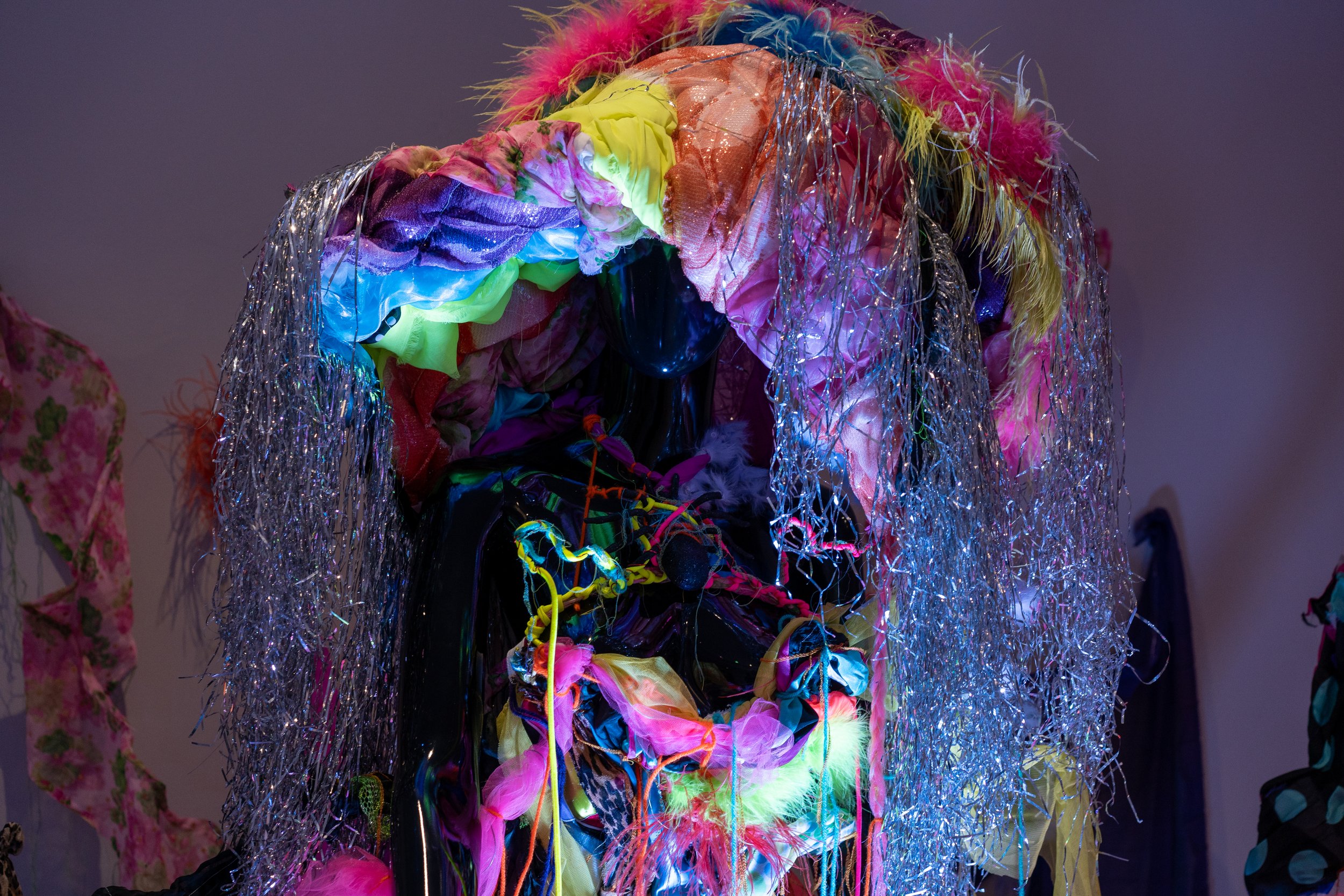Vibrant abstract art piece with colorful fabrics and metallic tinsel
