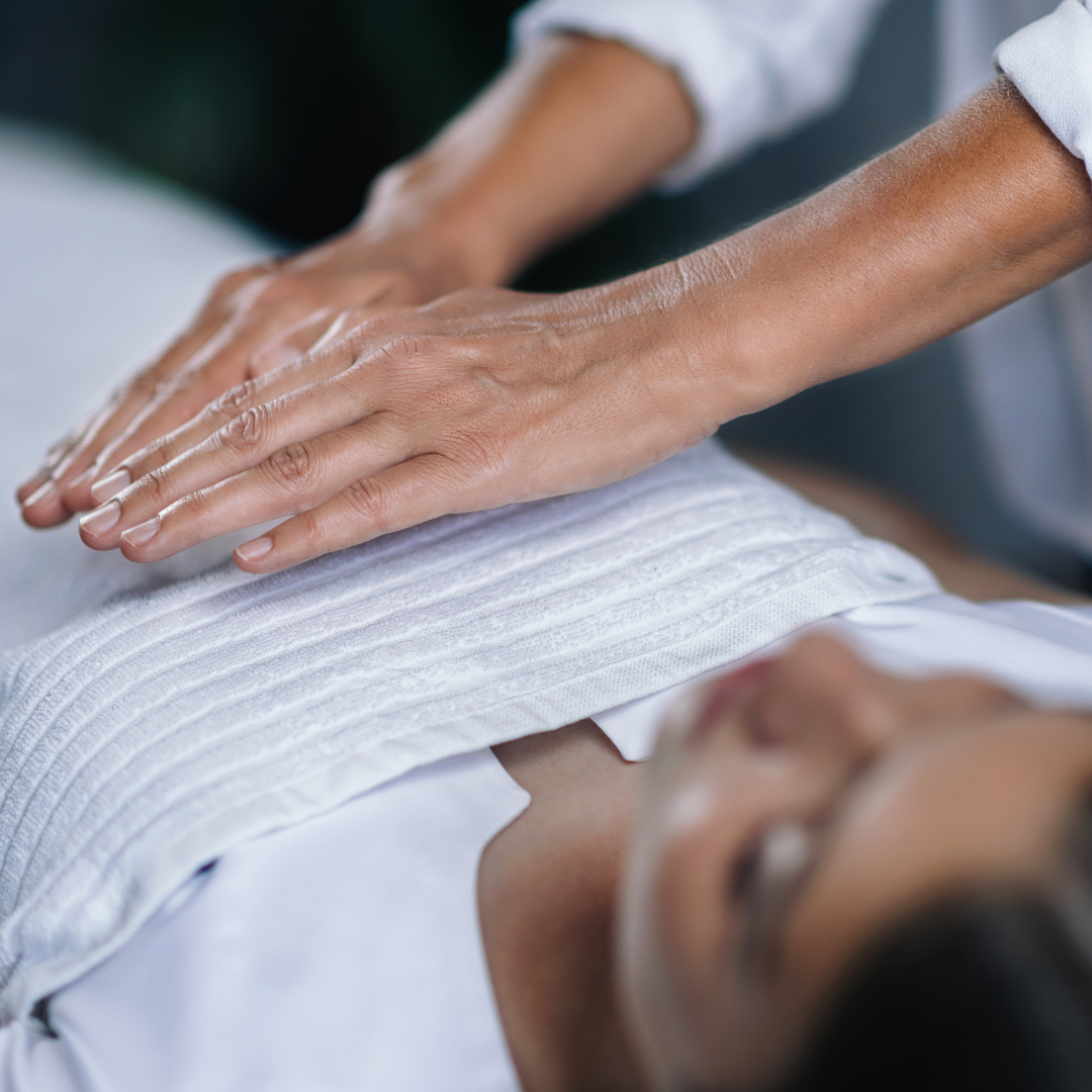 Hands hovering over the heart of a person reclining peacefully