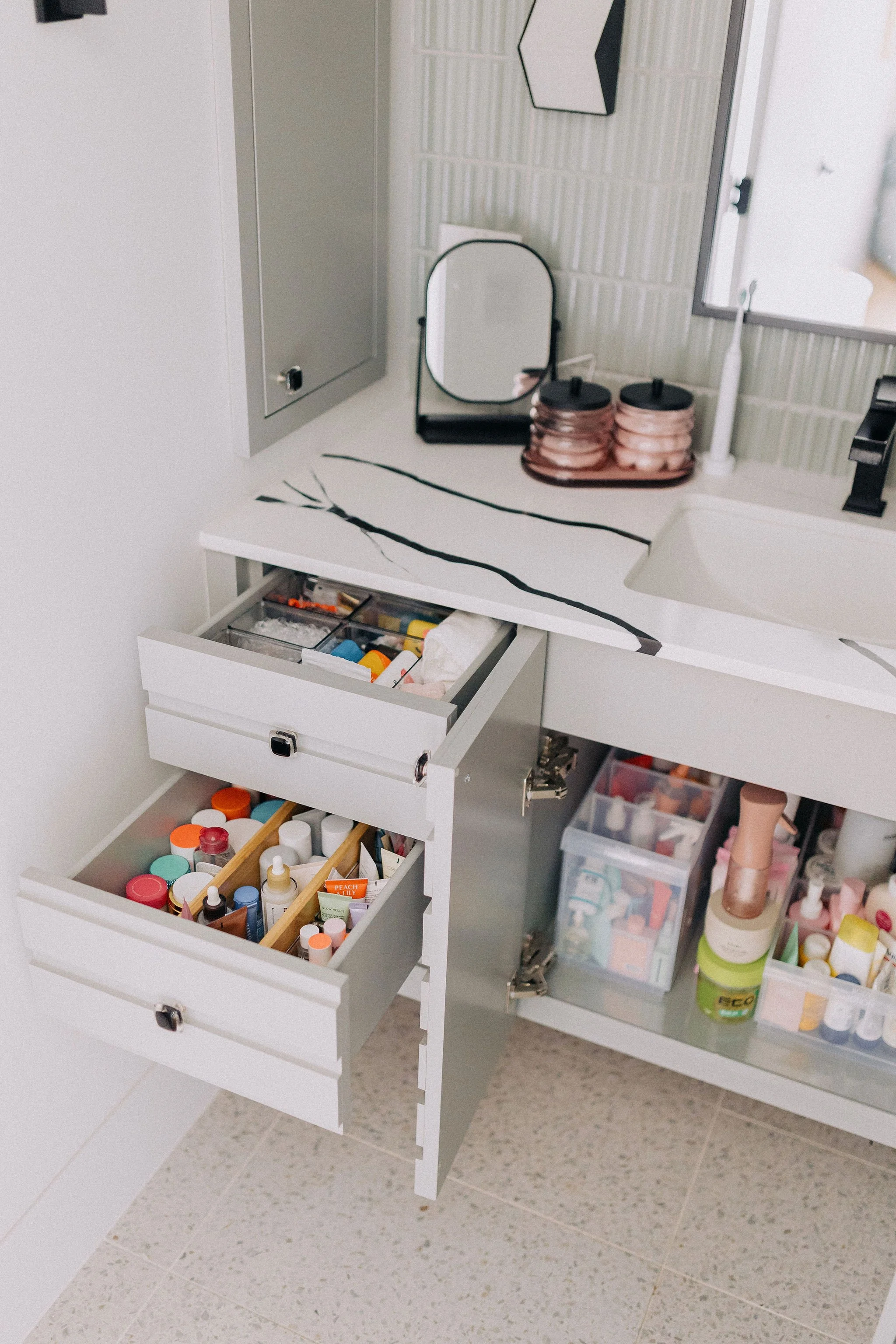 Organized primary bathroom with functional storage systems and professional home organizing