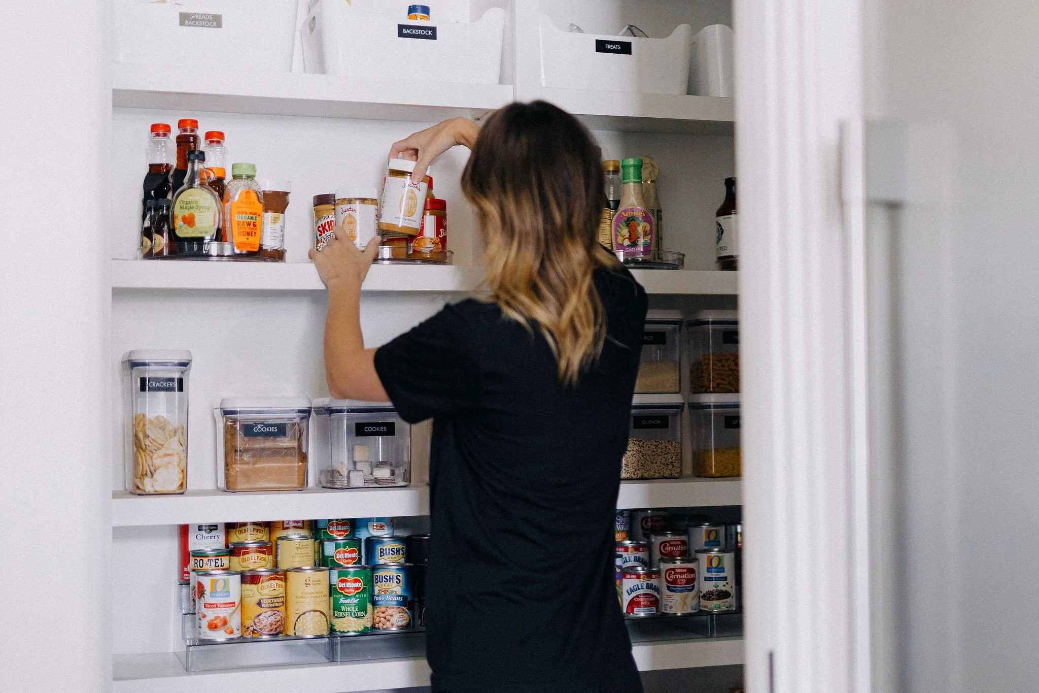 Professional organizer maintaining pantry shelves as part of home organizing maintenance service