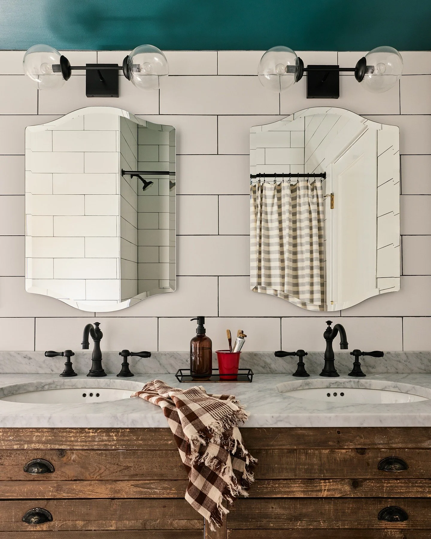Another view of the kids' bathroom. It's pretty satisfying to see the vanity tidy and cute like this&mdash;because, as anyone with kids can relate, it was generally covered in globs of toothpaste. I chose those curved mirrors to echo the scallop floo