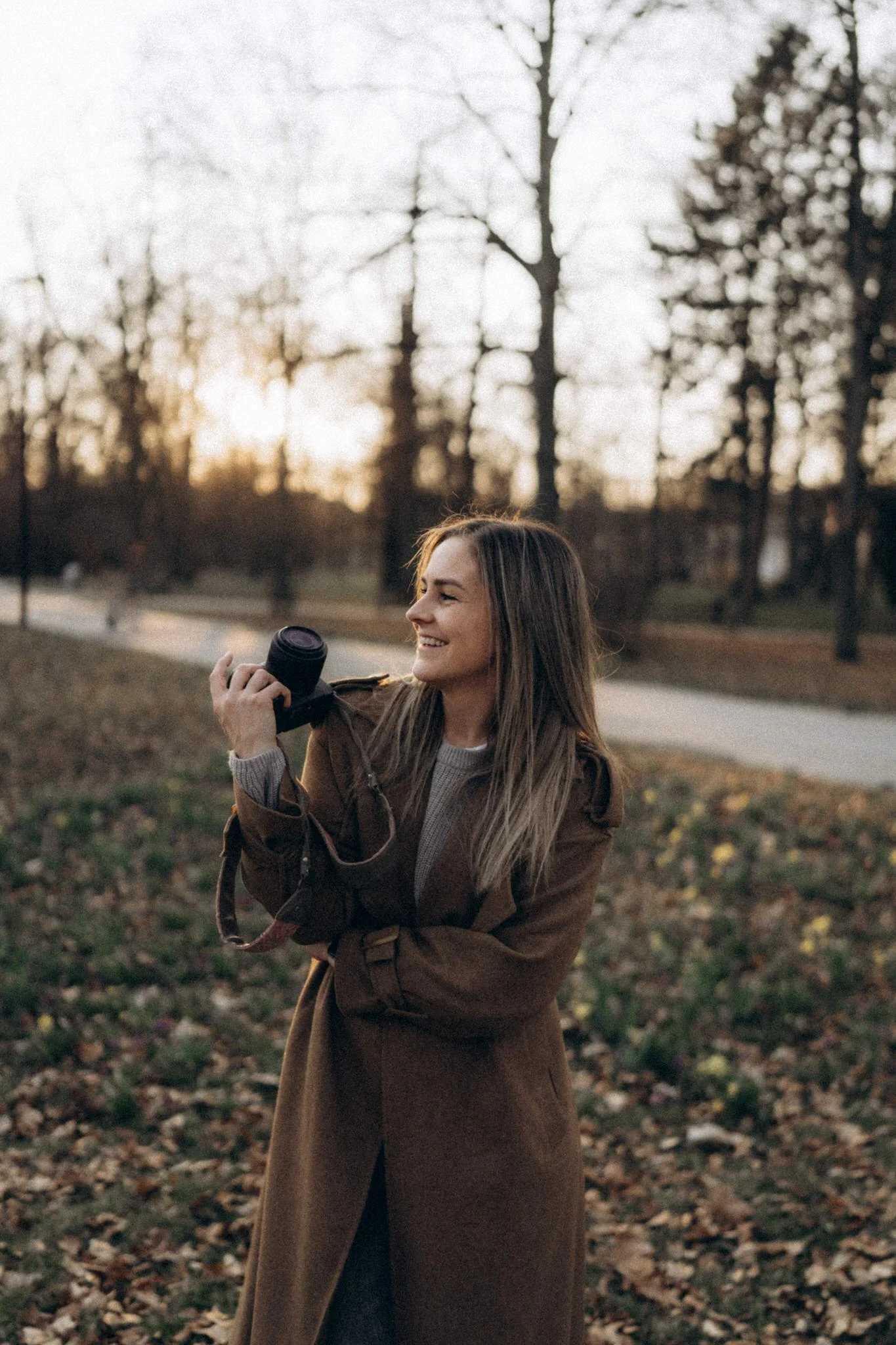 fotografka Most zena s fotoaparatem v ruce v parku pri zapadu slunka
