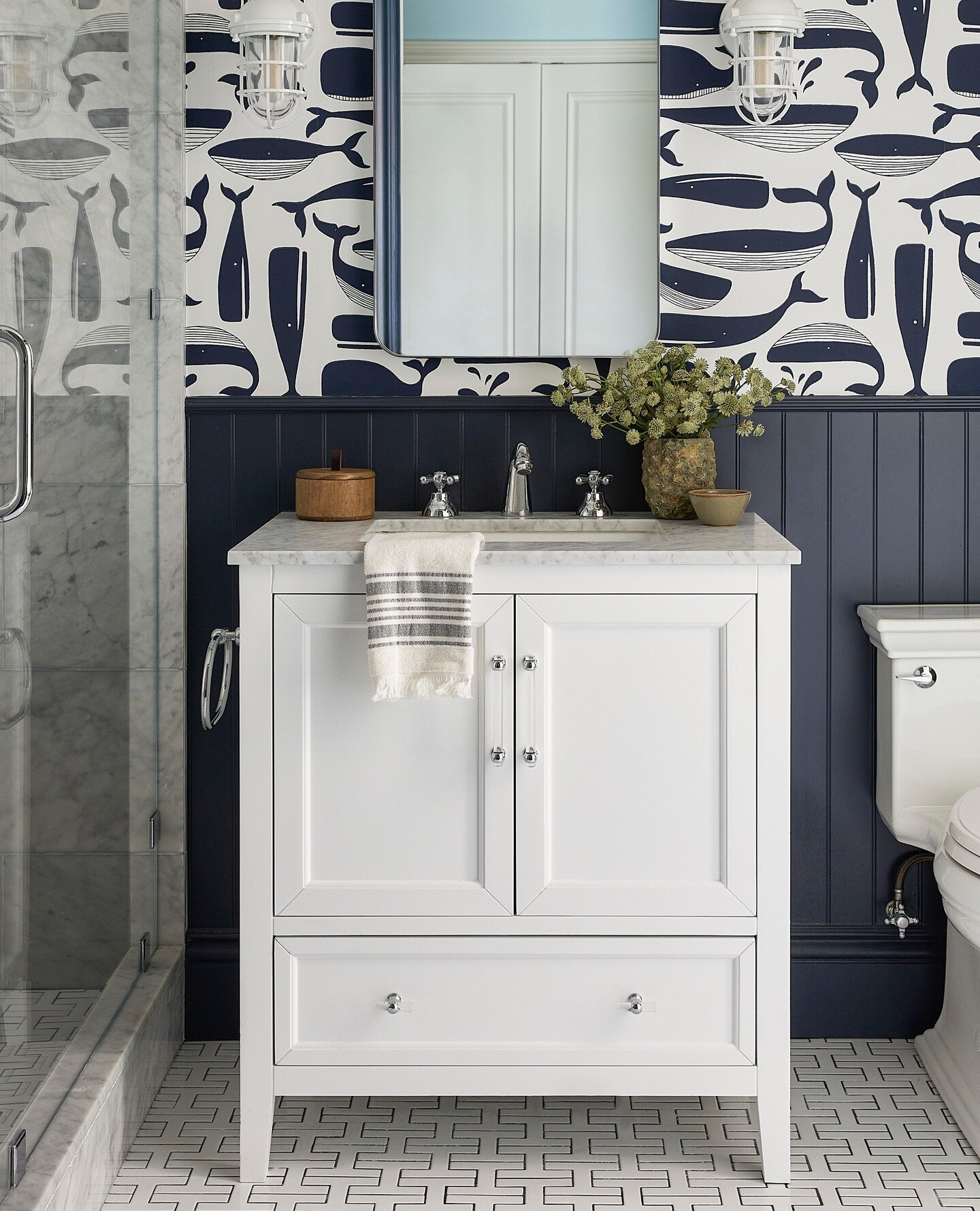 Tile Tuesday - is that still a thing? This playful, nautical inspired kids bathroom is full of fun details. Zoom in to see how the @fireclaytile chain homme pattern tile in white with a navy grout is making friends with the classic carrara marble in 
