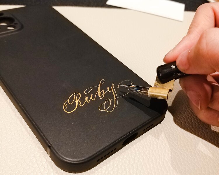 hong kong hk calligrapher personalizing black phone case in gold ink with calligraphy