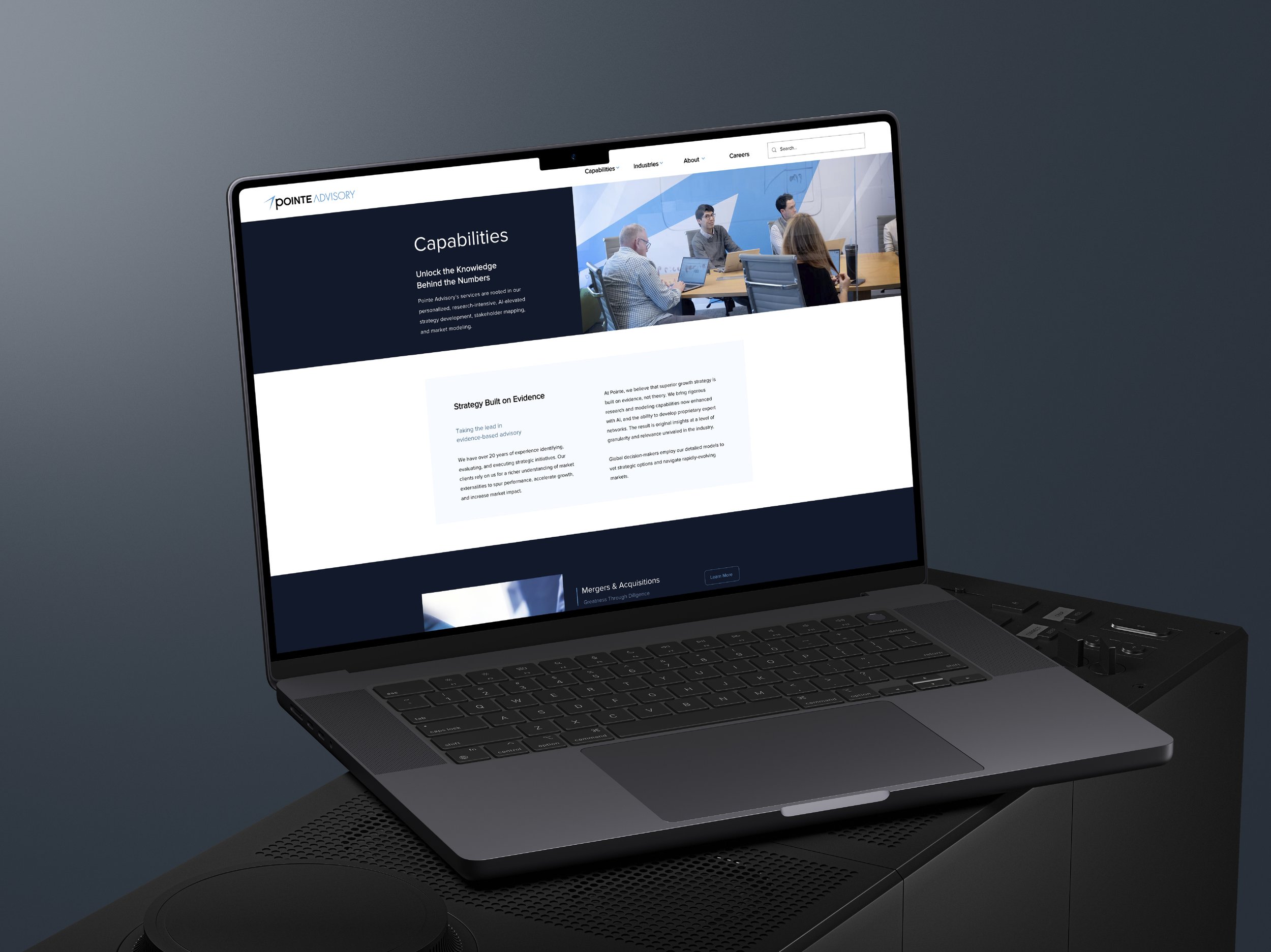 A laptop on a conference table displaying a website for Pointe Advisory with a focus on capabilities and strategy built on evidence. The screen shows a header, an image of a business meeting, and text sections.