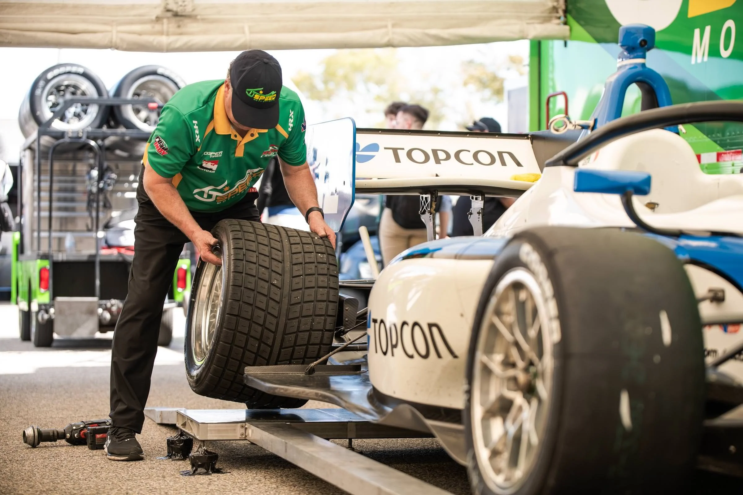 Race car mechanics put new tires on Topcon's Indy Lights car
