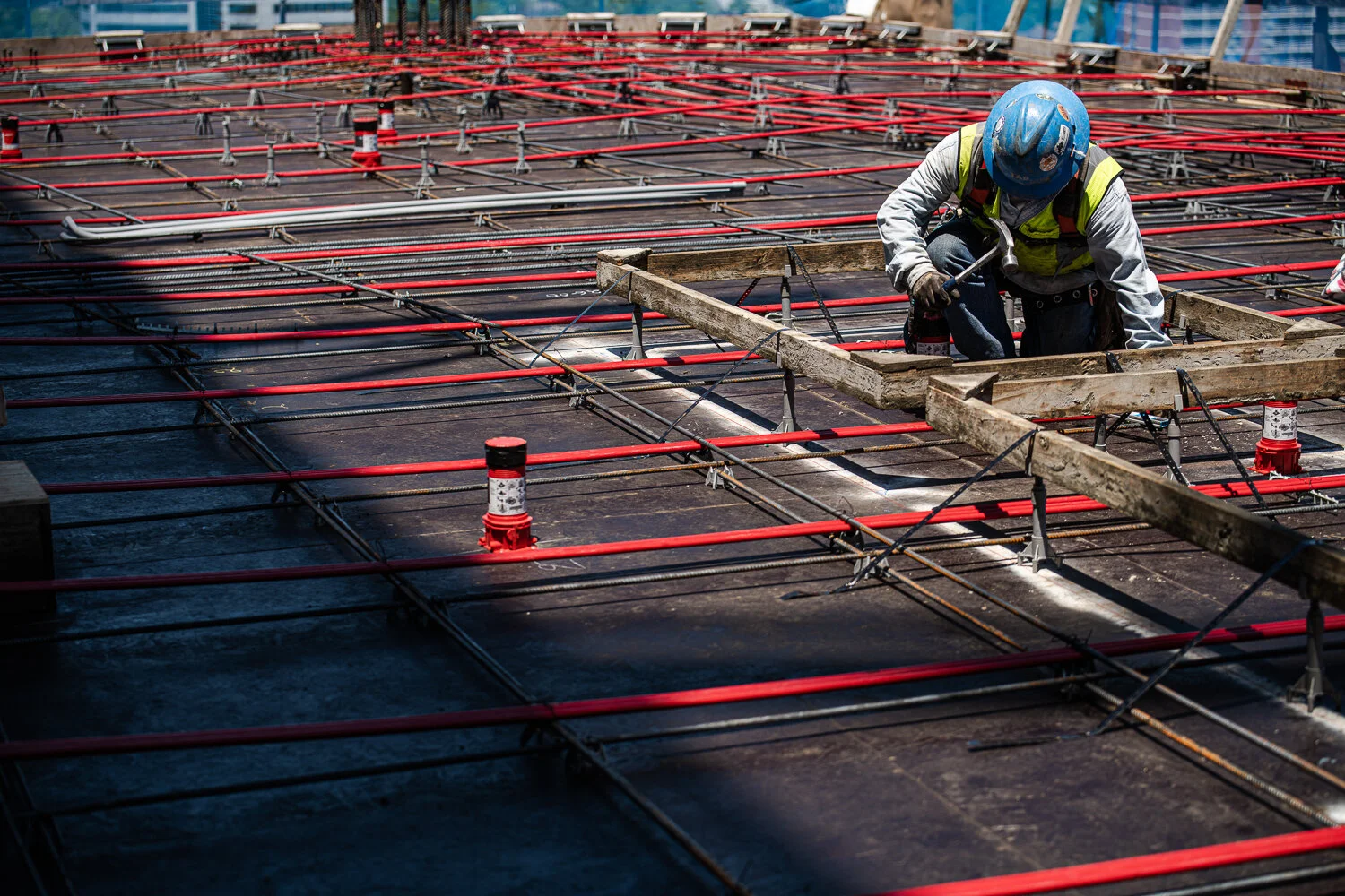 Construction photography showing Construction worker laying down rebar by David Loi