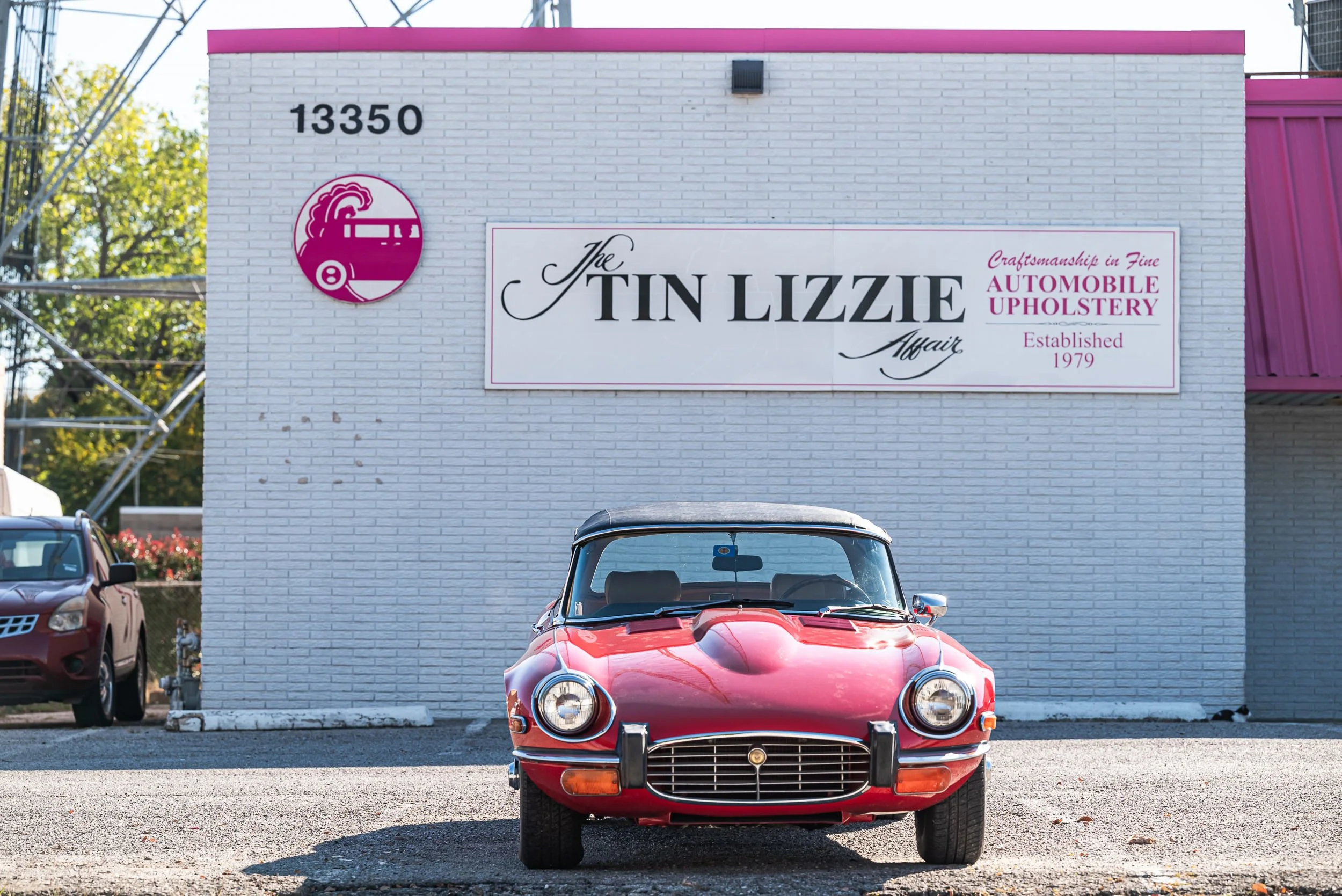 A red Jaguar parked in front 'The Tin Lizzie Affair' and additional text about craftsmanship and upholstery by David Loi Studios.