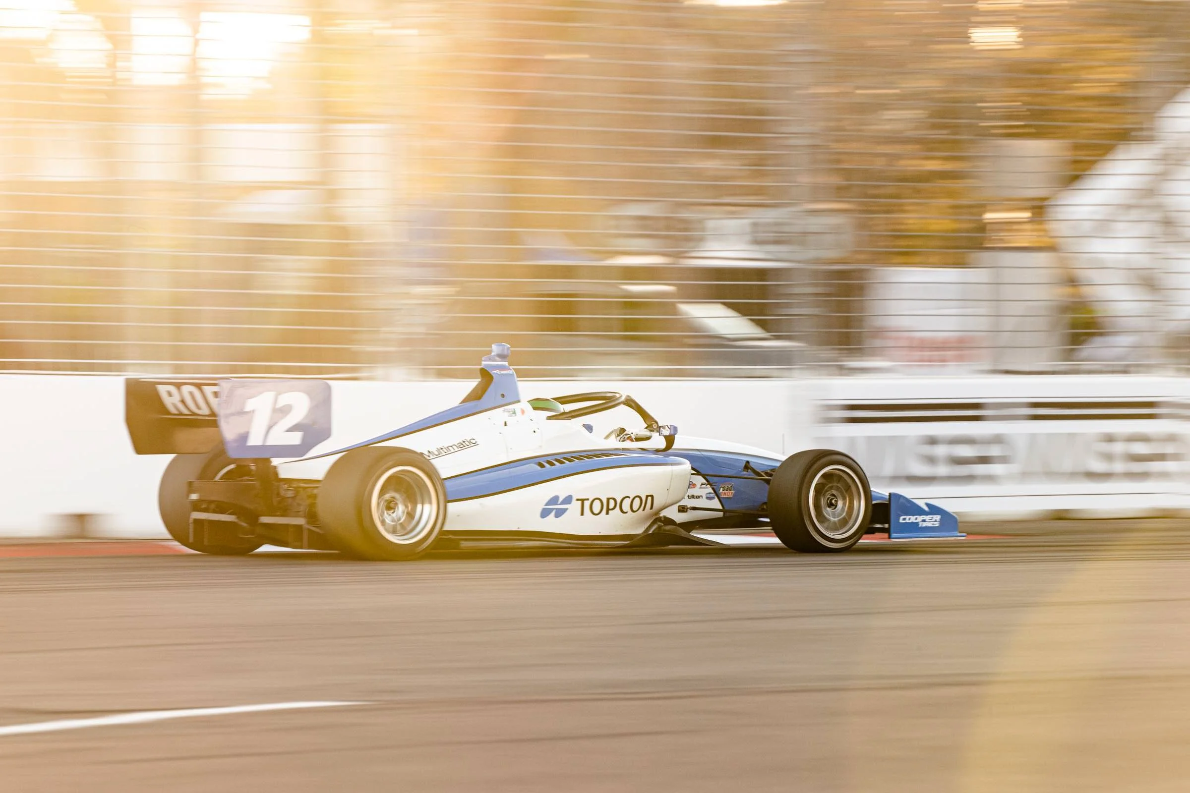James Roe's Topcon Indy Lights car rounding a corner at sunset
