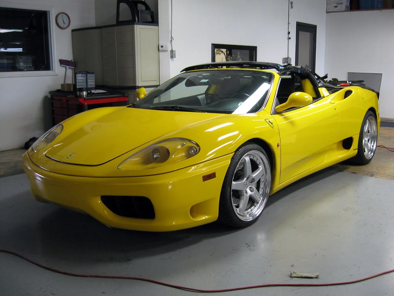 Yellow Ferrari sports car in a garage.