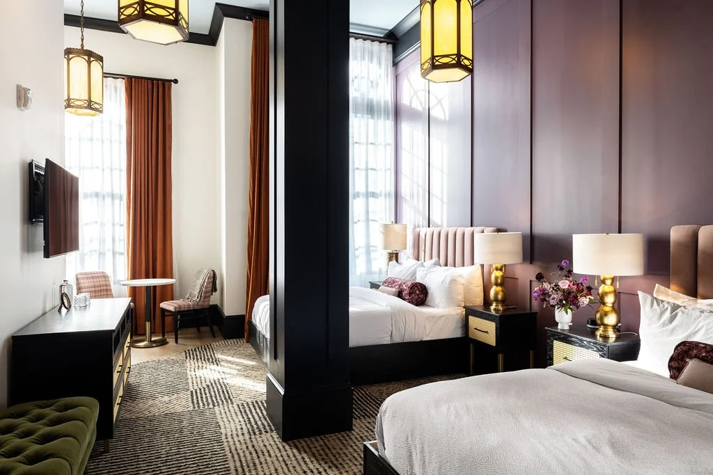 Modern guest room at Hotel Thaxter with tall windows, warm wood accents, and boutique accommodations in downtown Portsmouth, New Hampshire.