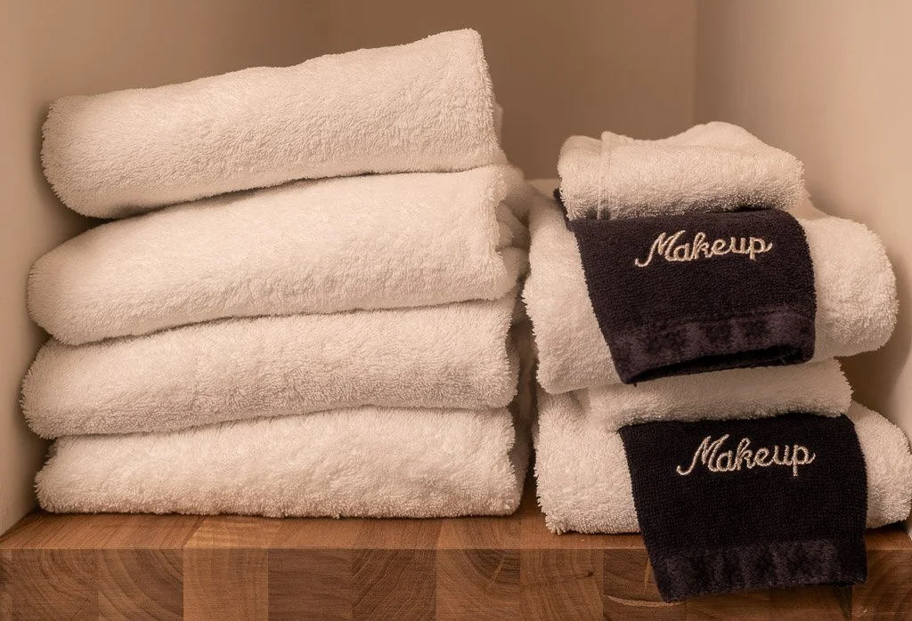 Folded white and black towels with makeup embroidery in the Downtown Luxury Condo at Hotel Thaxter in Portsmouth, New Hampshire.