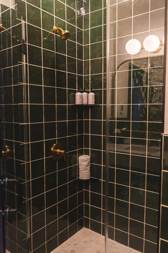 Dark green tiled shower in the Downtown Luxury Condo at Hotel Thaxter in Portsmouth, New Hampshire.