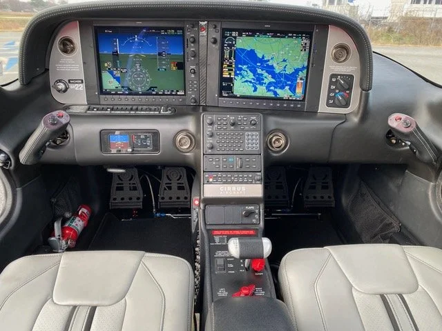 Cockpit of a Cirrus SR22 aircraft with digital flight displays and controls.