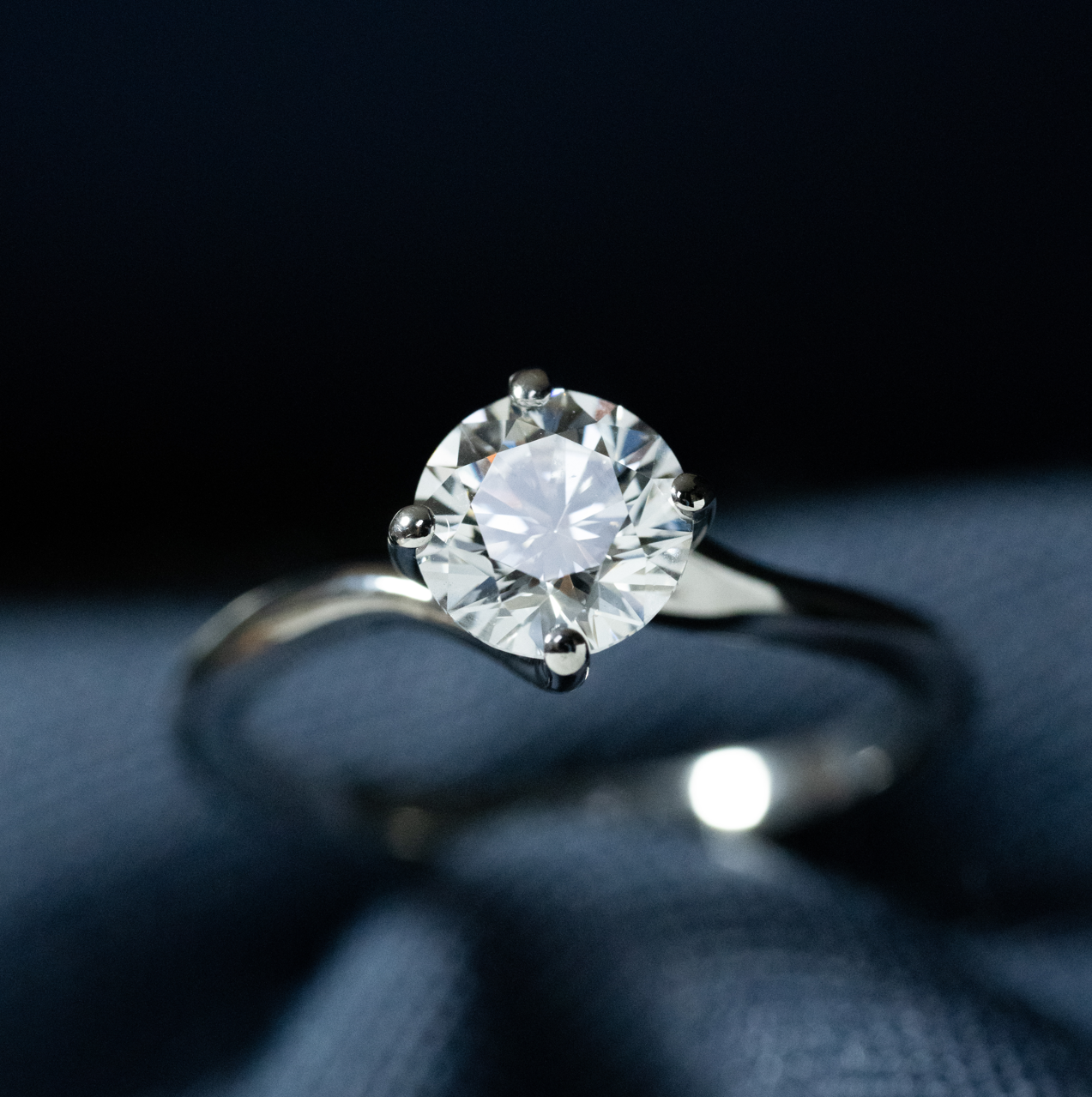 Anillo solitario de oro blanco con diamante central de corte redondo.