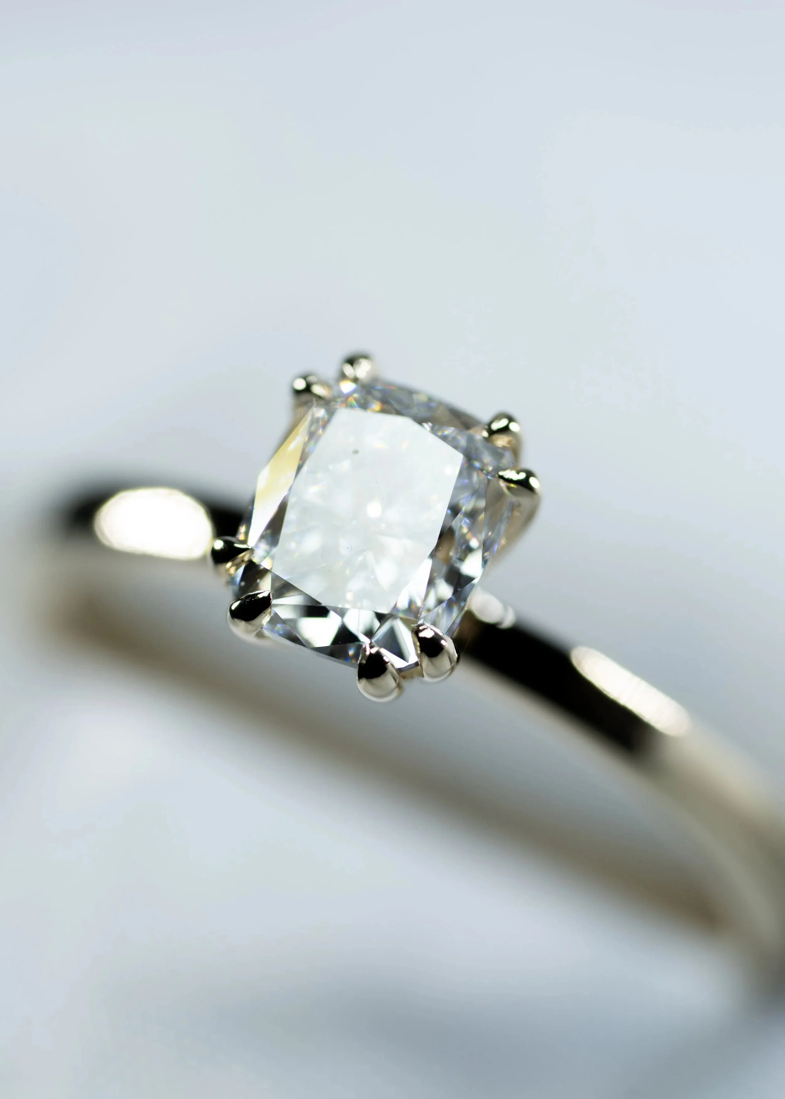 Anillo solitario de oro amarillo con diamante central de corte cushion.