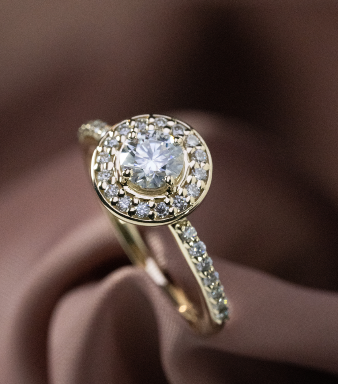 Anillo de compromiso fancy con diamante central corte redondo, halo de diamantes y diamantes laterales, diseño de Pérez Filoteo.