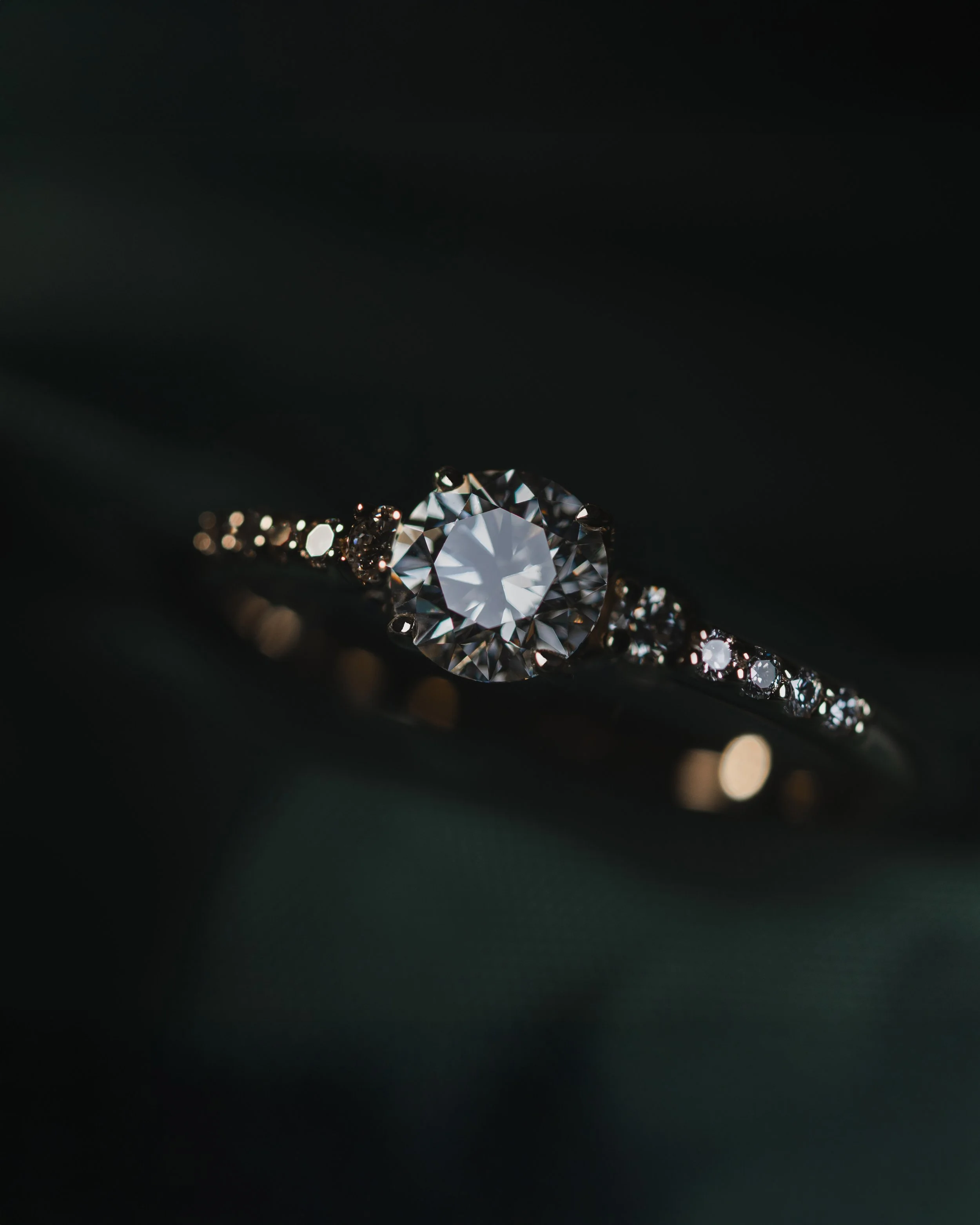Anillo de compromiso con diamante central brillante y laterales engastados con diamantes