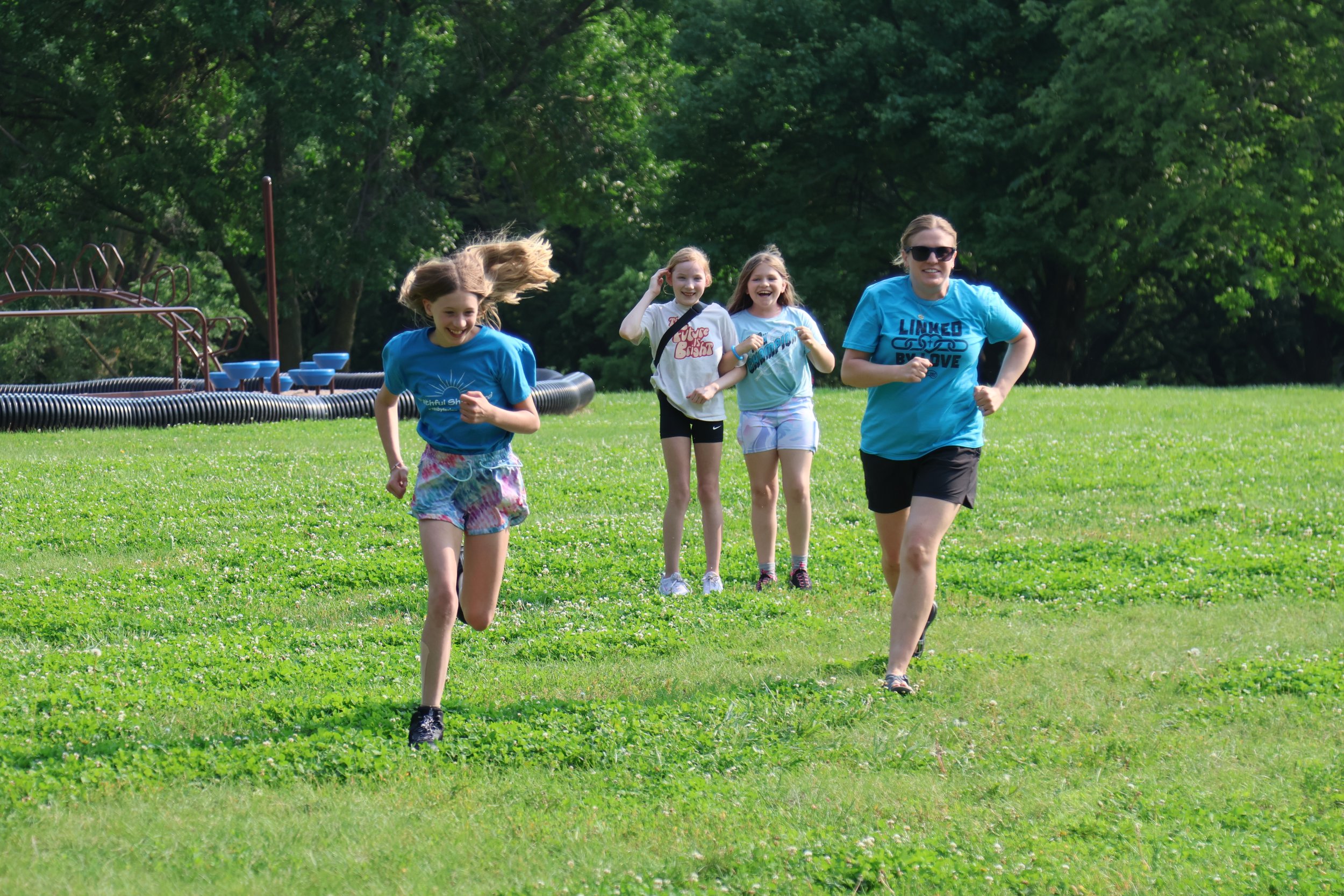 Campers running in a grassy field