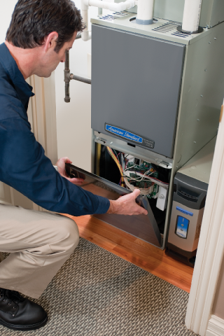 A technician working on a heating or cooling system in a home.