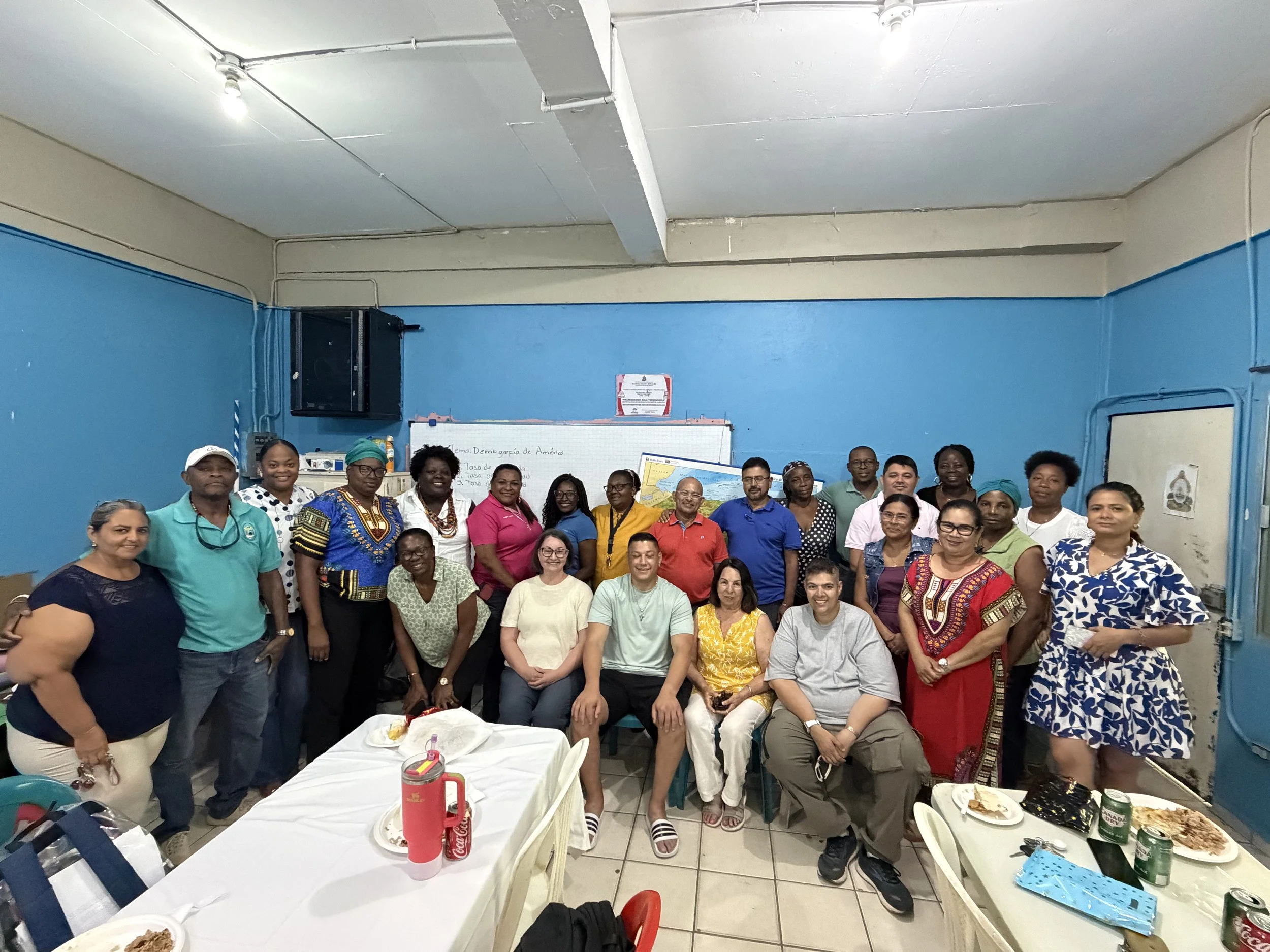 The New City Honduras missions team seated in the front row, surrounded by local teachers and community members at the school in Punta Gorda, Honduras, after sharing a meal together