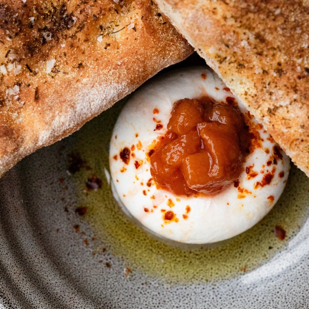 We&rsquo;ve been cooking over a wood-fired hearth since the day Stoneburner opened, and it remains the backbone of our kitchen. That slow, steady heat shapes everything we do&mdash;charred vegetables, roasted meats, blistered flatbreads, deep winter 