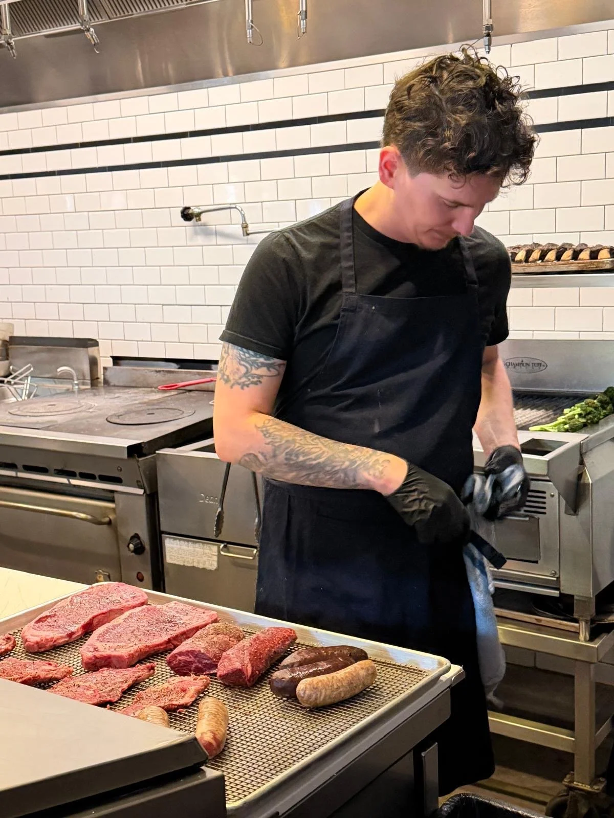 Chef Alex Gonzalez of PRIMITIVO prepares cuts of beef and chorizo for the grill at a Seattle pop-up event
