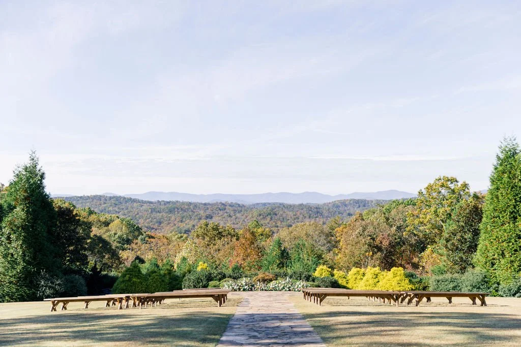 A scenic outdoor setting with a path leading to a view of distant rolling hills and trees during daytime.