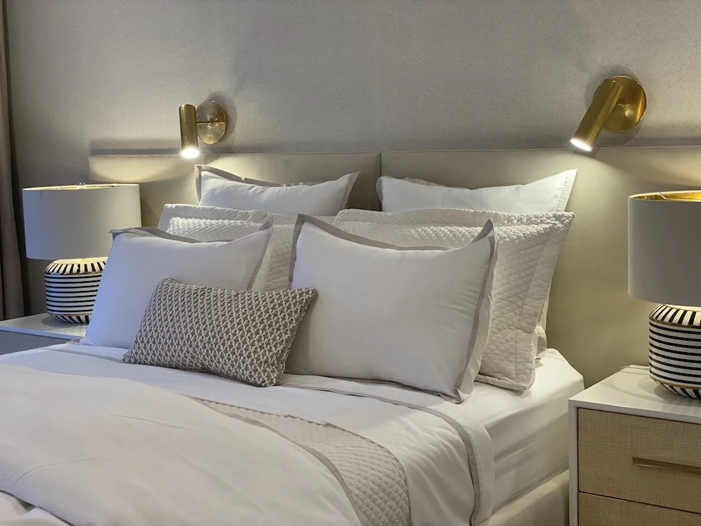 gold-sconces-pillows-modern-bedroom.jpg