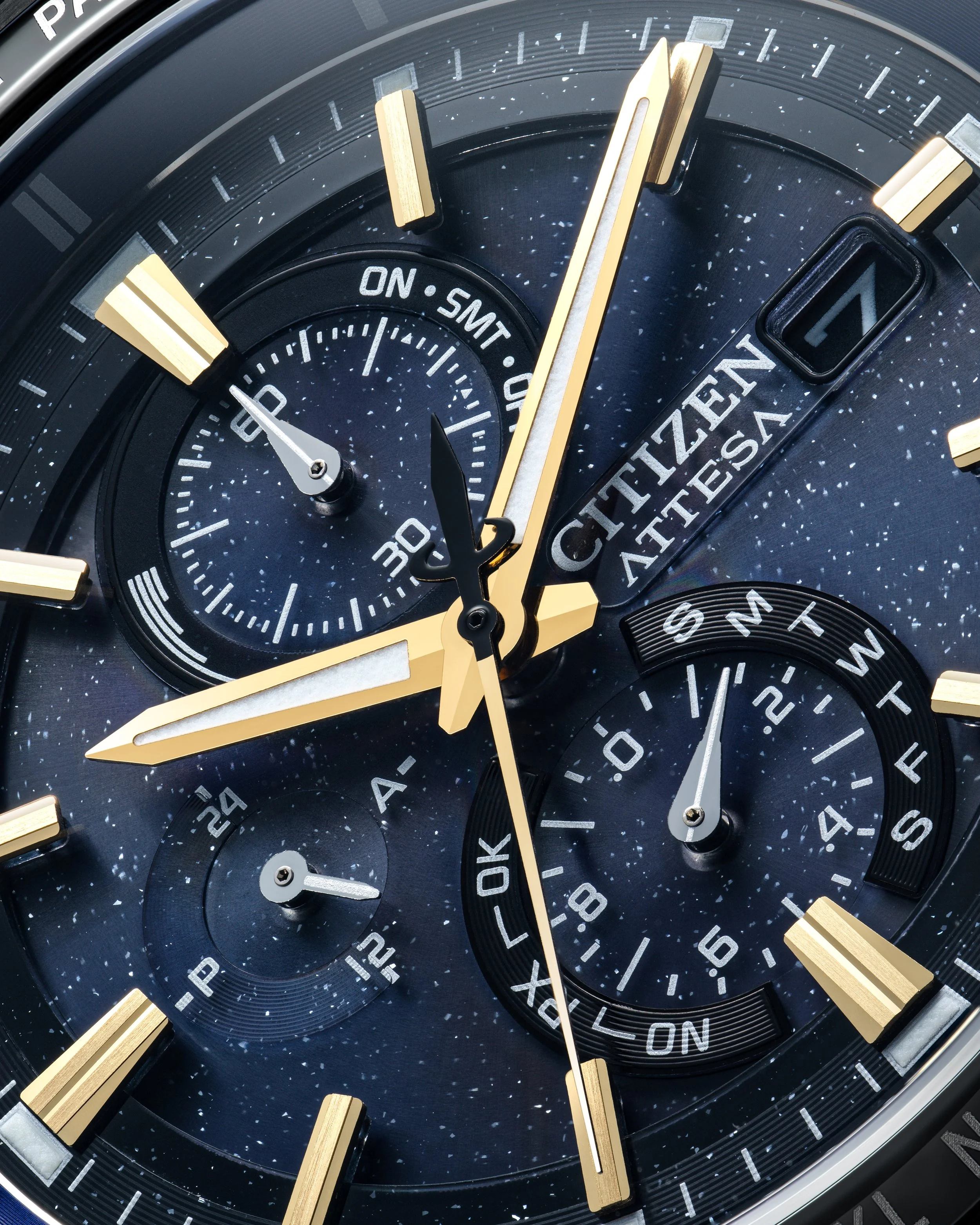 Close-up of Citizen wristwatch with black dial, gold accents, and multiple subdials showing time, date, and other functions.