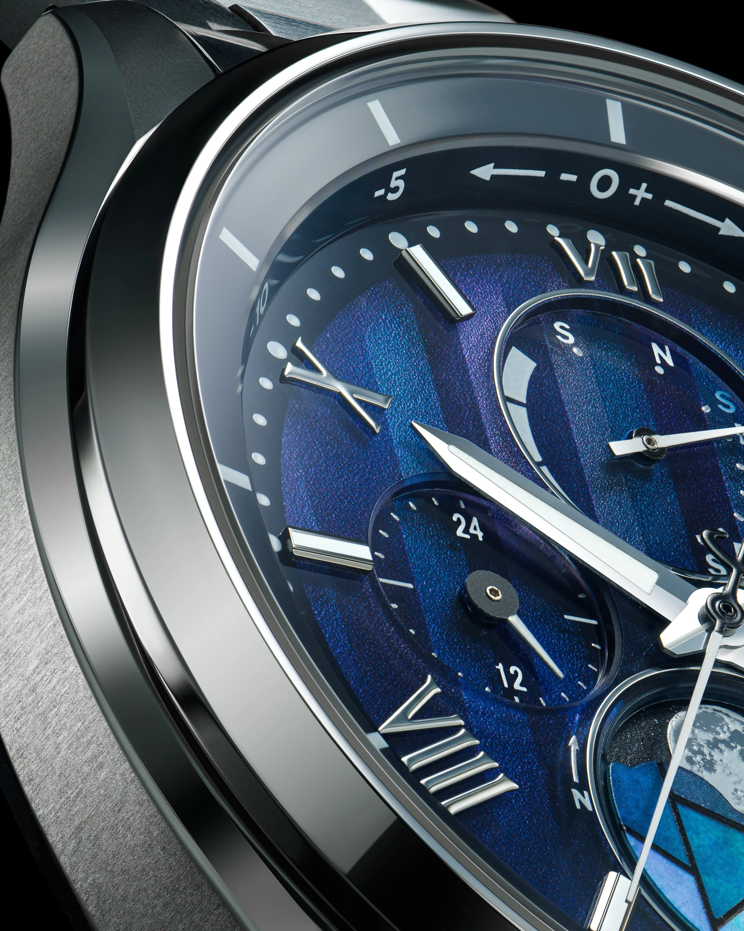 A close-up of a luxury wristwatch with a blue dial, Roman numerals, and multiple subdials, showing detailed features of the watch face.