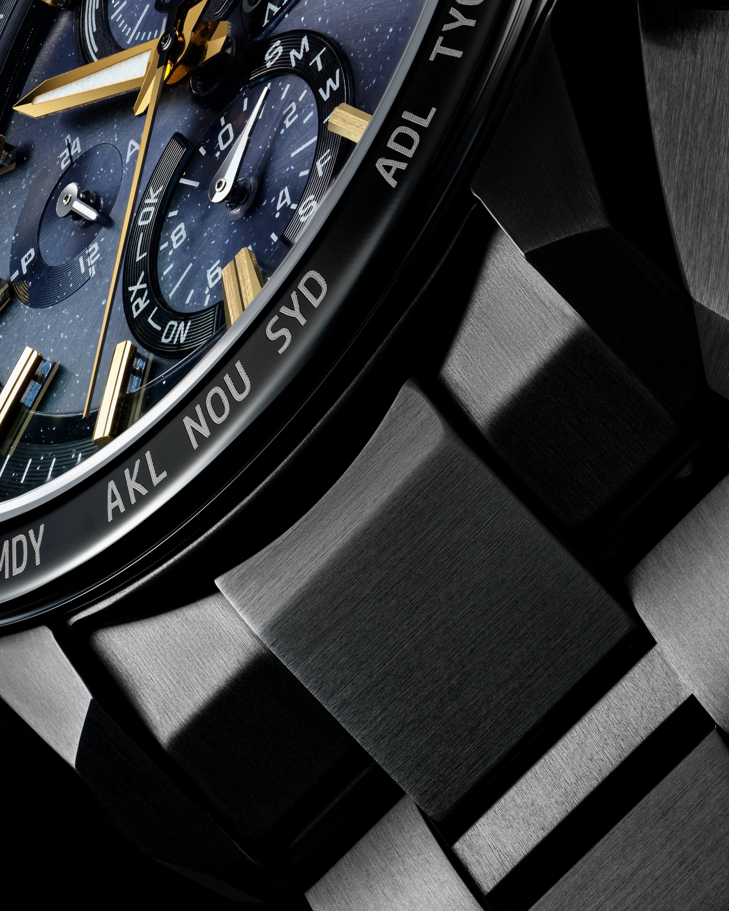 Close-up of a luxury wristwatch with a black metal band, featuring detailed dials, gold accents, and city abbreviations on the bezel.