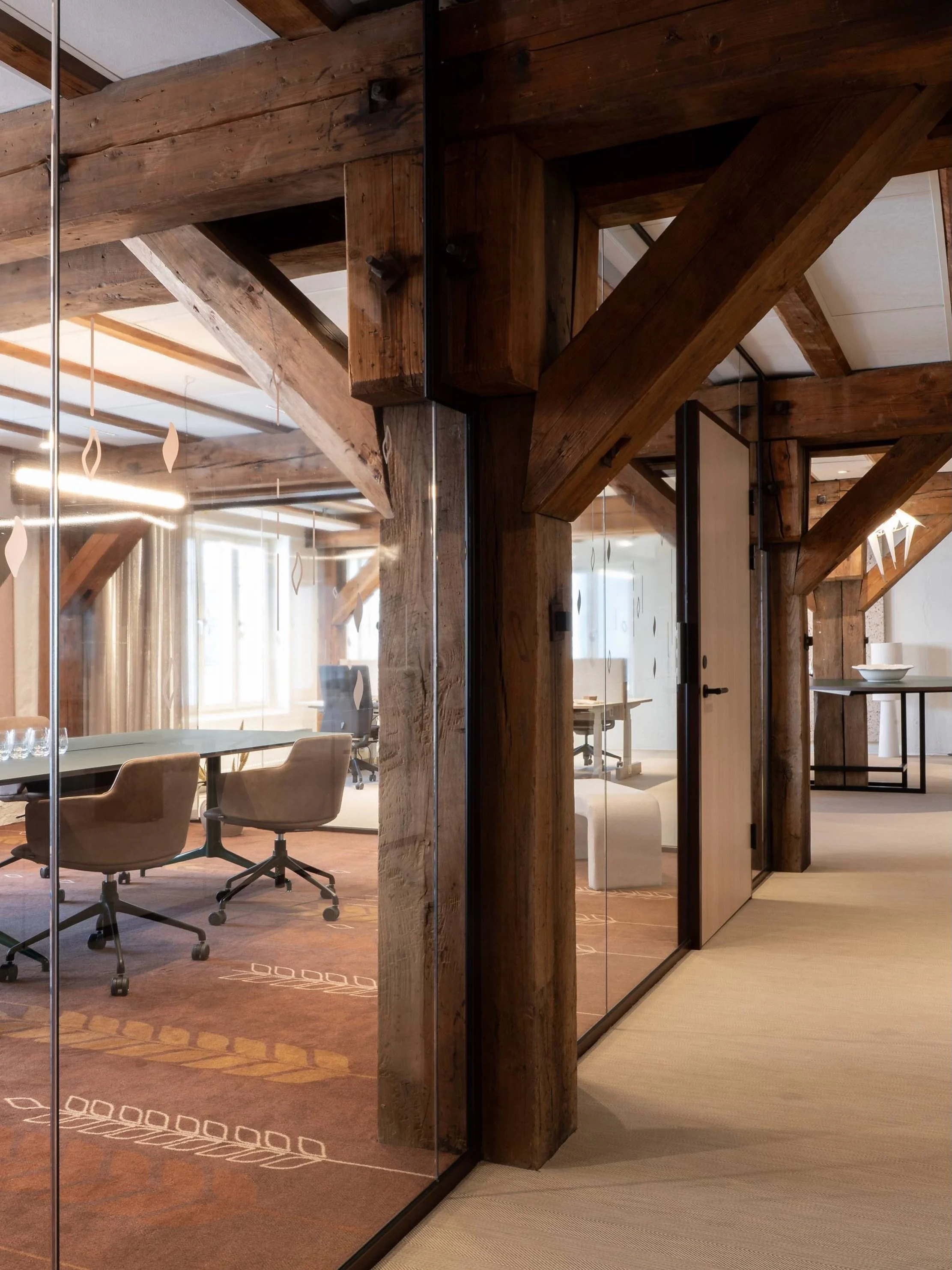 Originale t&oslash;mmerdragere og s&oslash;yler st&aring;r som synlige spor av byggets historie, mens et moderne arbeidsmilj&oslash; vokser frem rundt dem. Gulvet er 2tec2 Herringbone Dune &ndash; vevd vinyl bygget opp i flere lag rundt en glassfiber