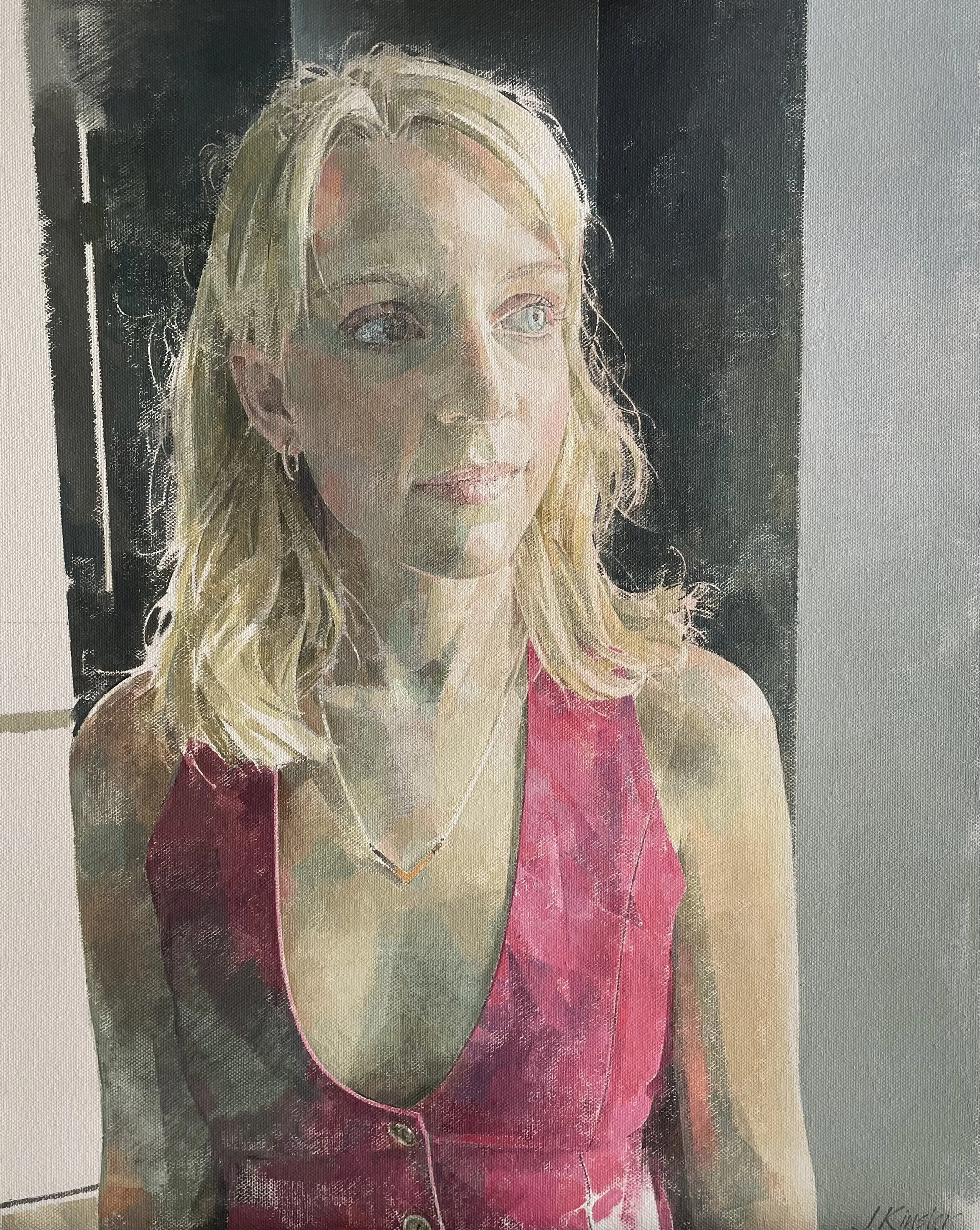 Portrait of a young woman in red waistcoat looking out a window