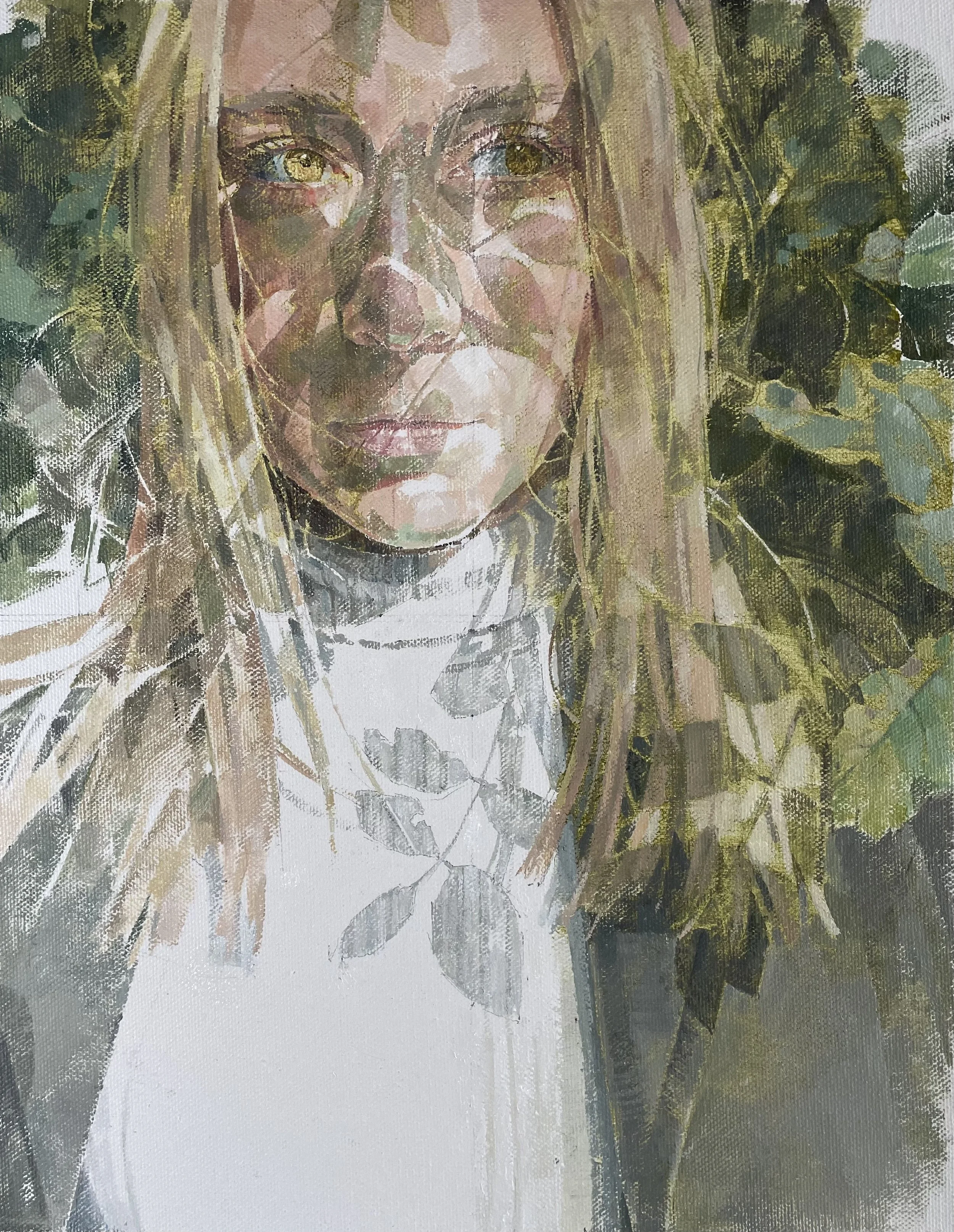 Portrait of a young woman with leafy shadows over her face