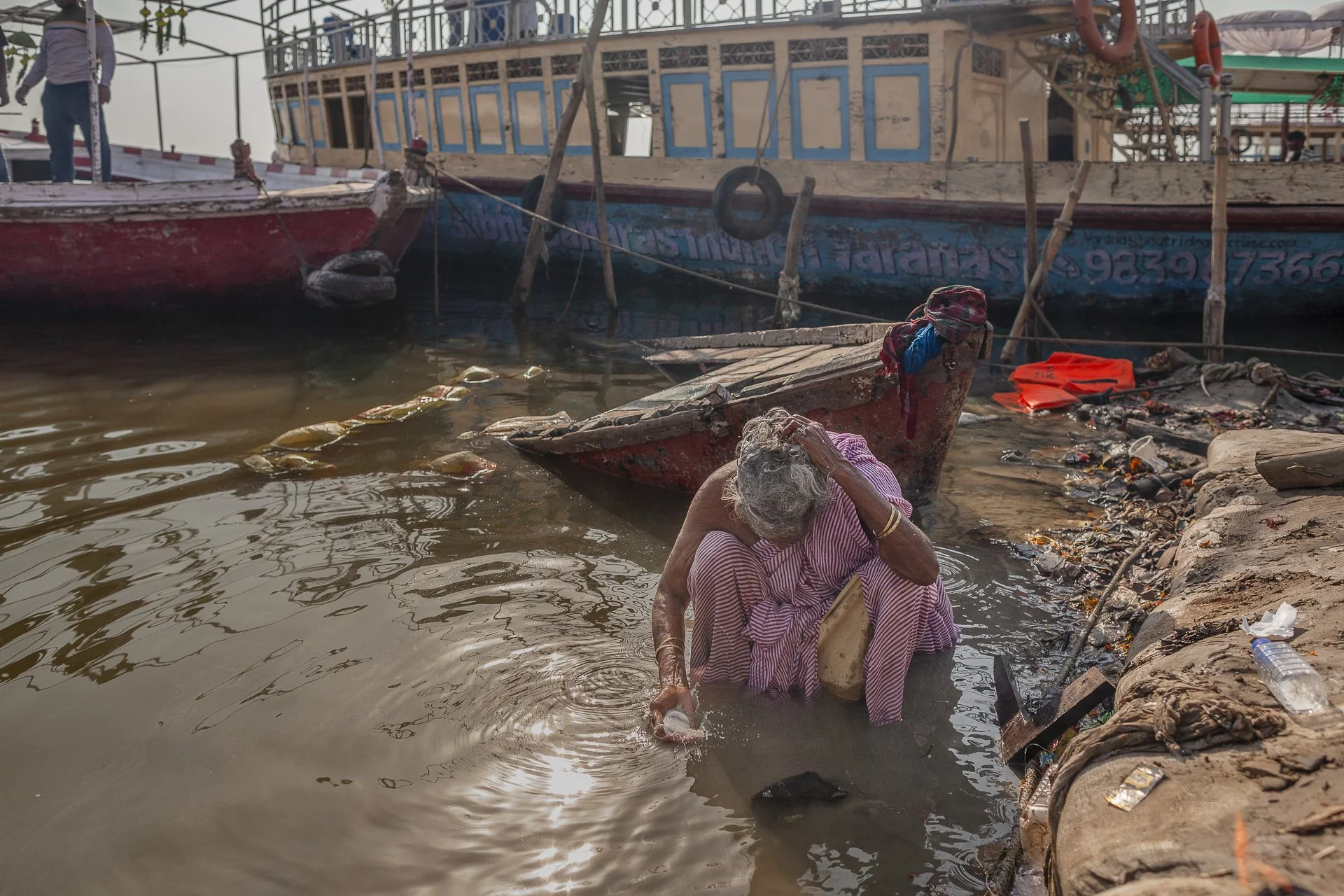 old woman bathing in the ganges, varanasi