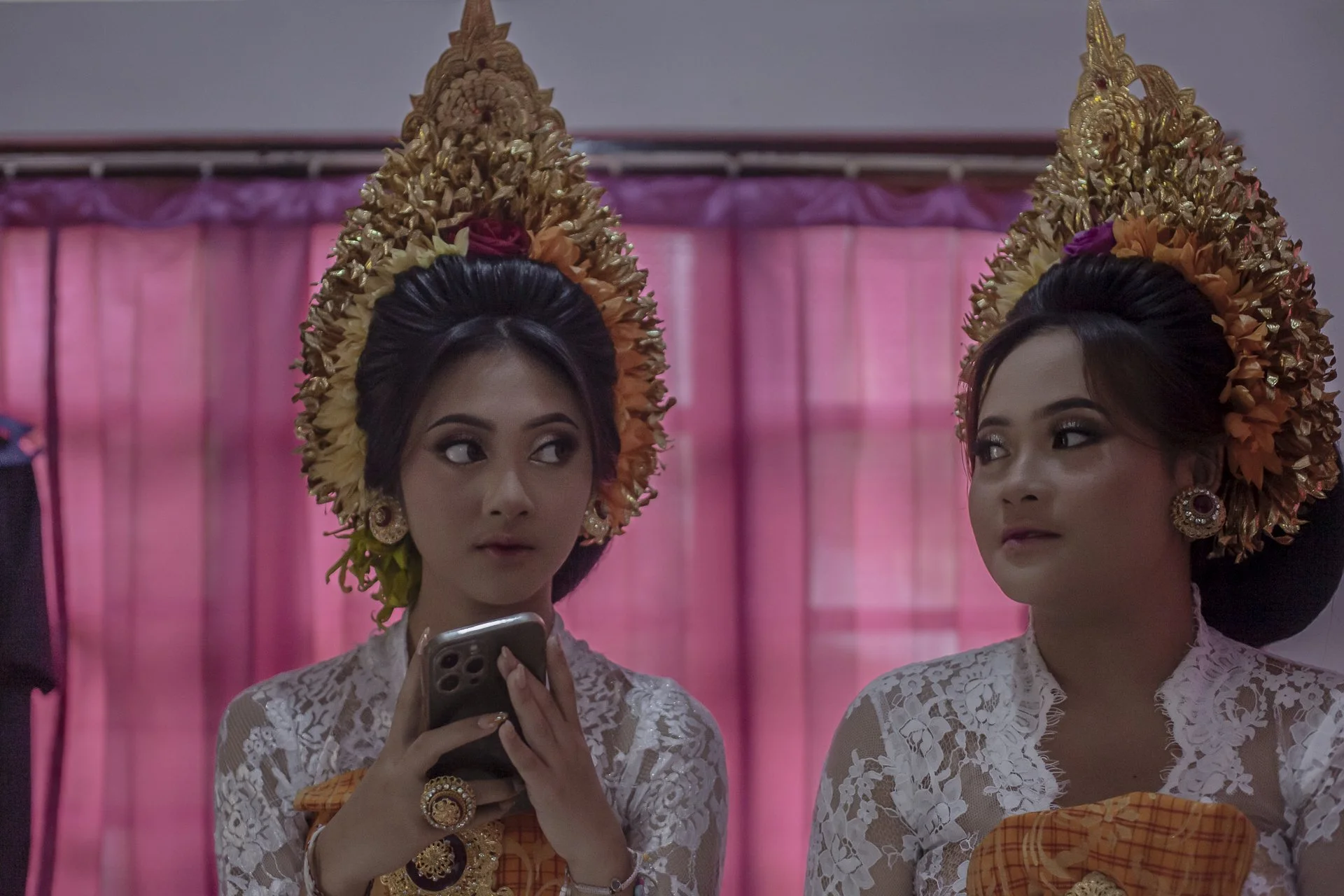 sisters in traditional outfits, waiting for tooth filing ceremony, Bali, Indonesia