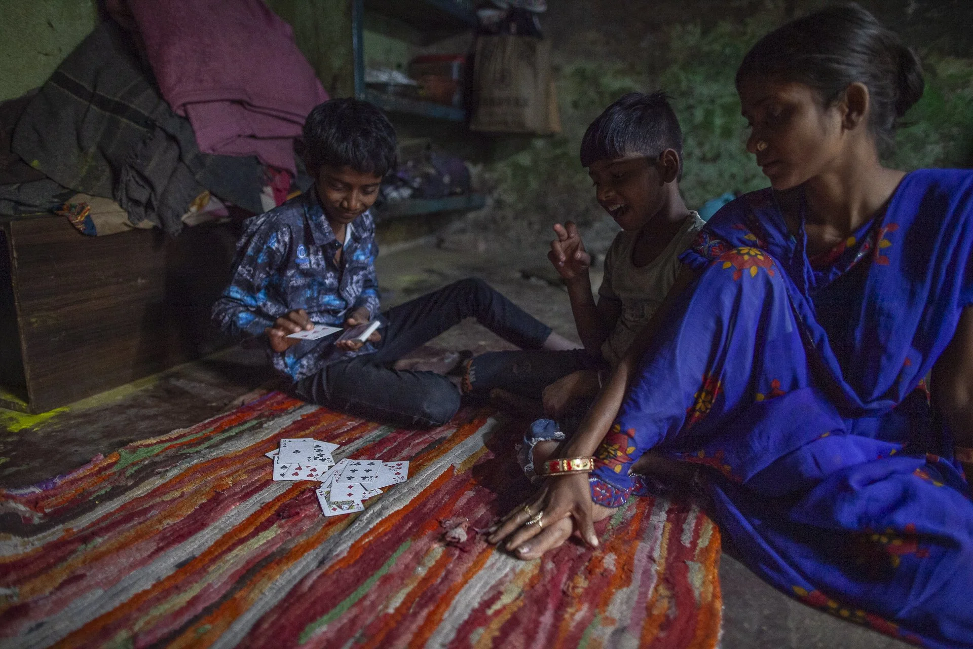 woman with children sitting on a rug in their home