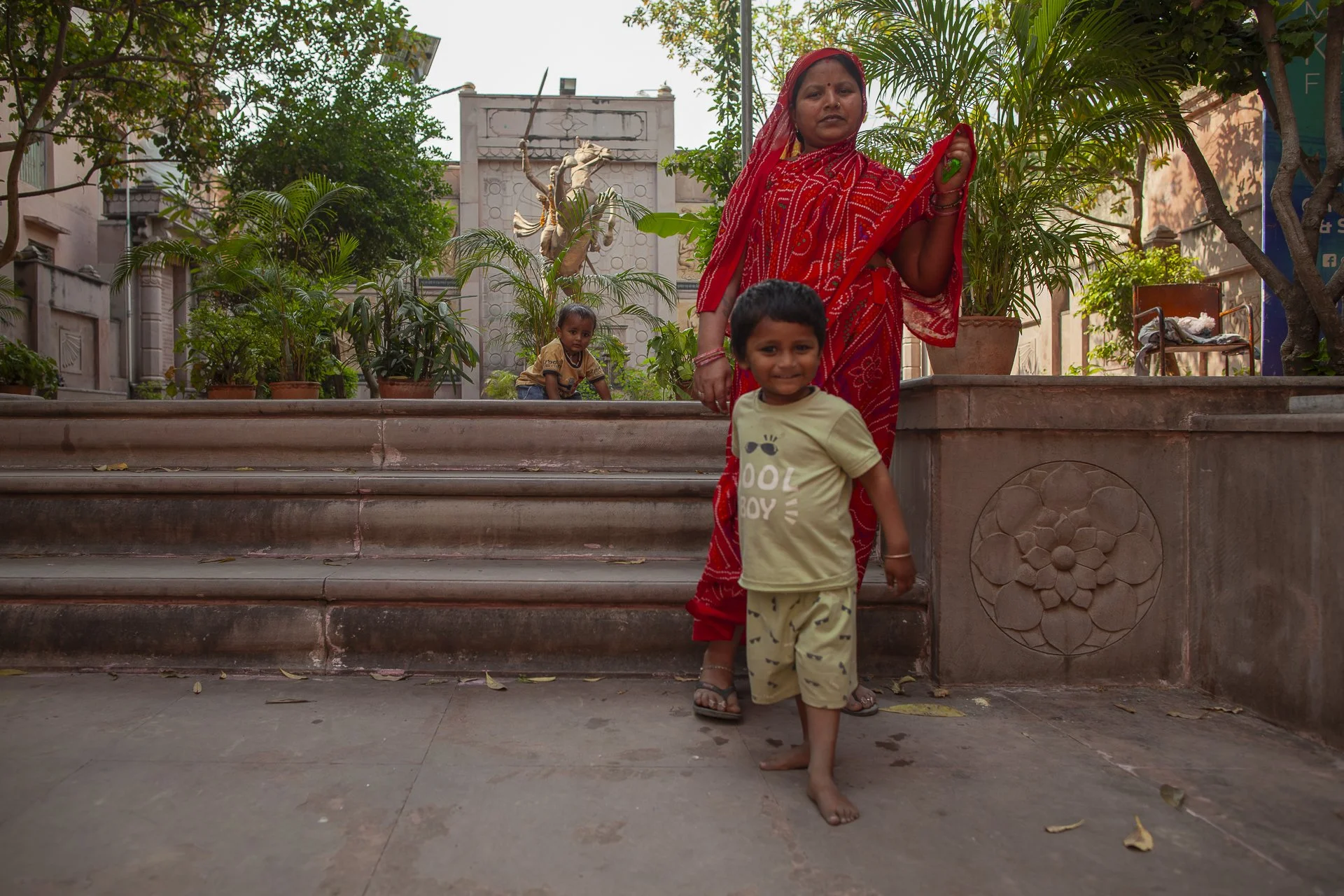 mother in red sari with her son in the park