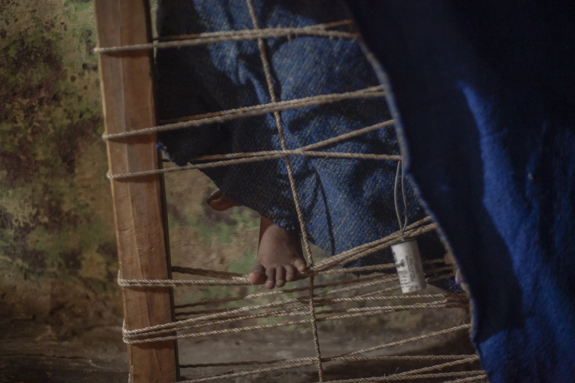 young boy playing on charpoy