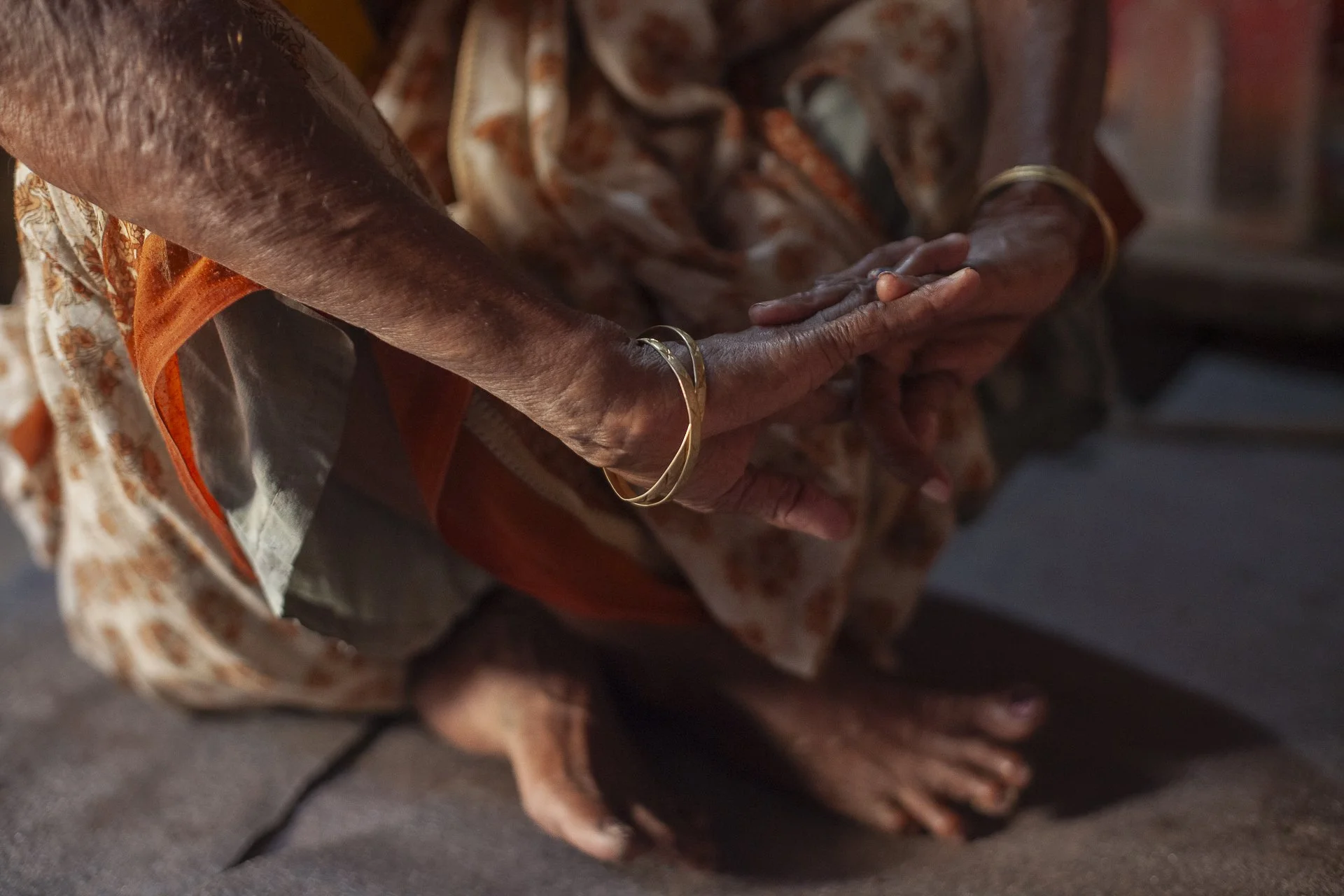 old woman sitting with bangles and sari