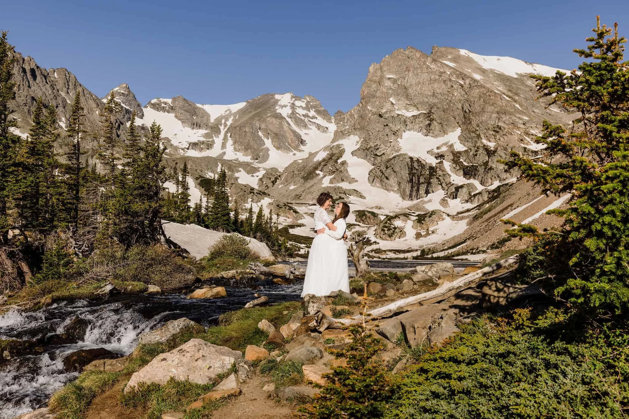 A couple stands in front of a large mountain