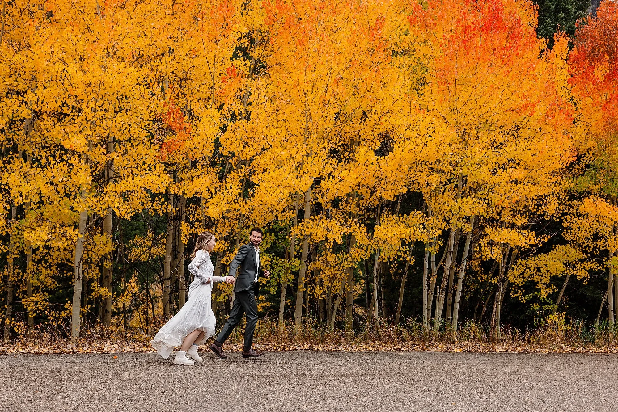 Couple runs with yellow and orange aspens behind them