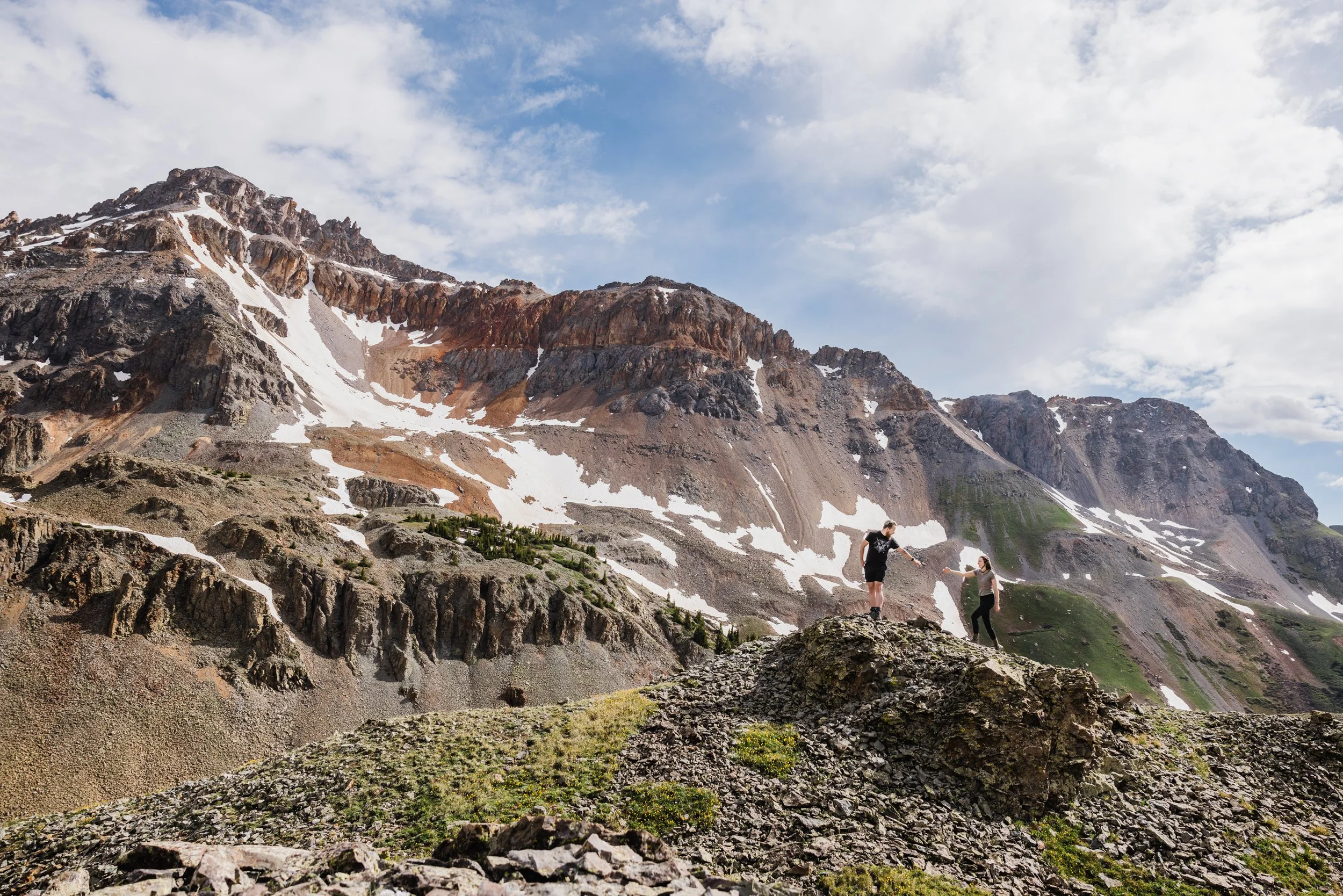 Lisa and Alex climb a rock in the mountains