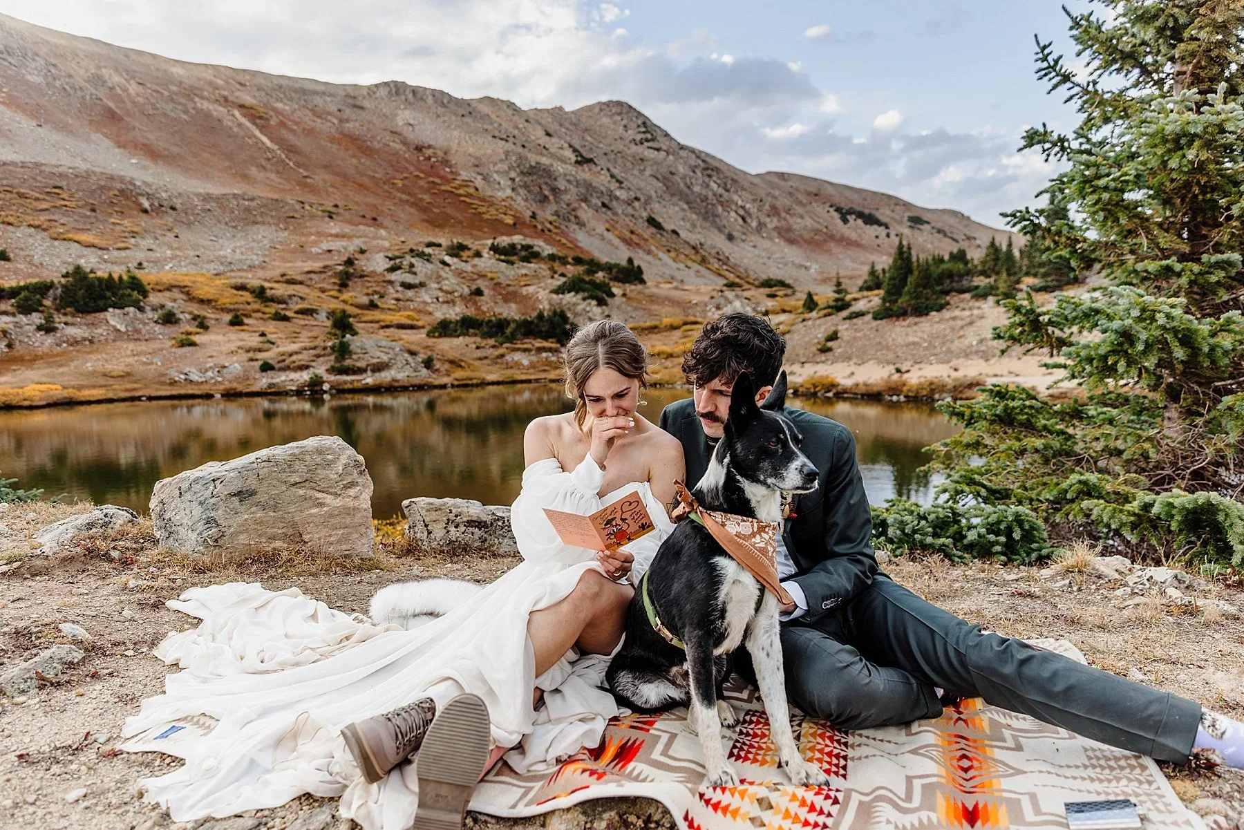 A couple reads a letter together with their dog
